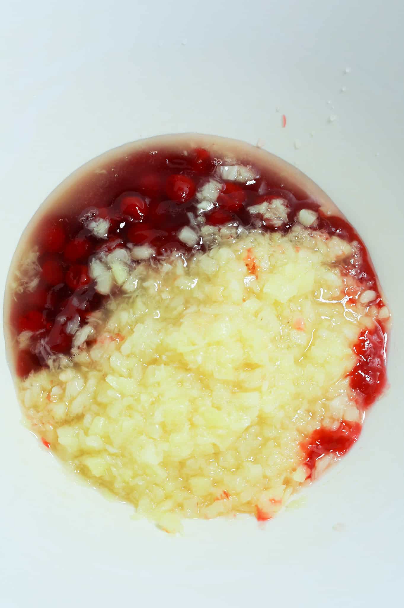 cherry pie filling and crushed pineapple in a mixing bowl