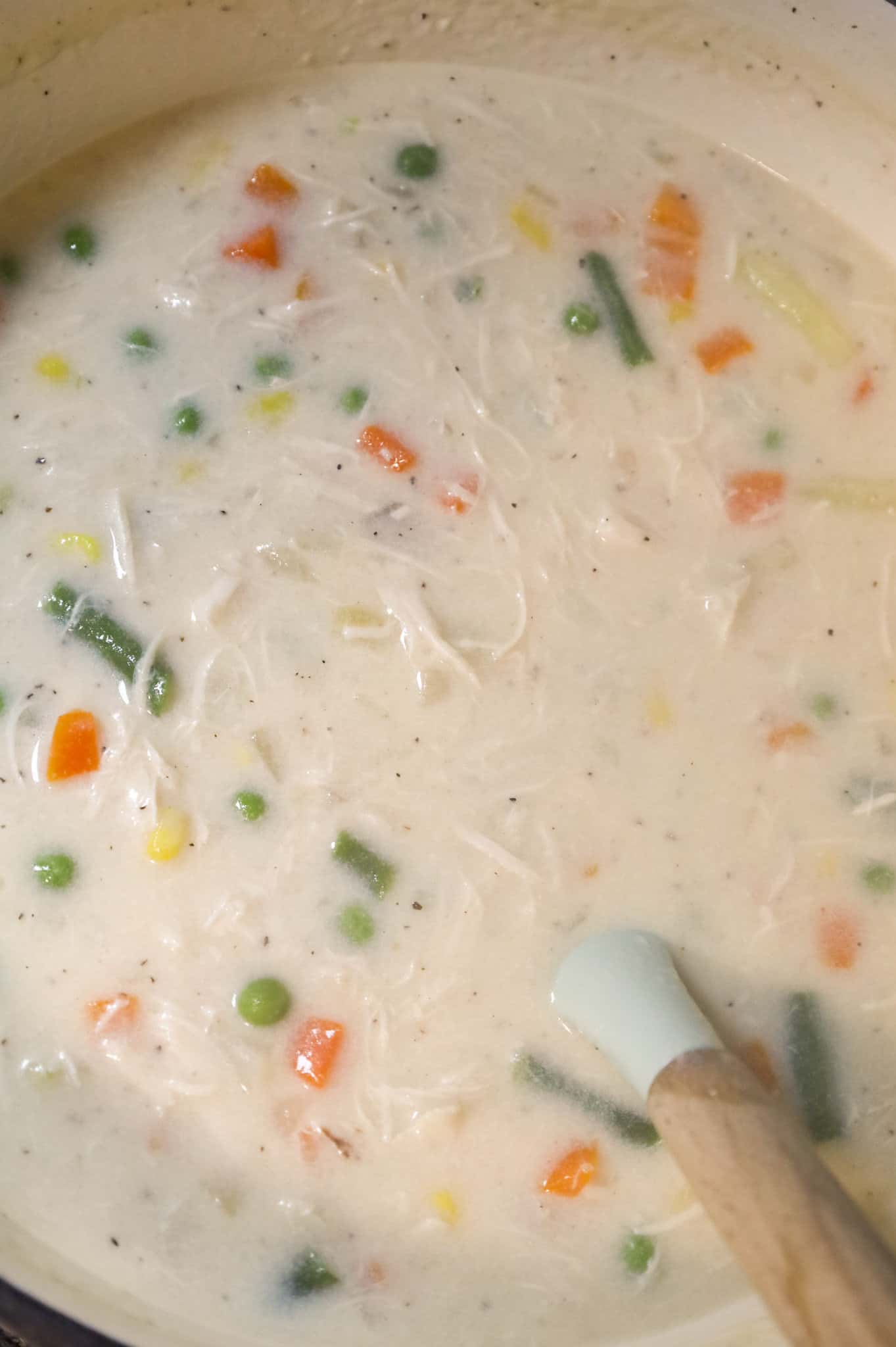 stirring vegetables and shredded chicken into cream soup