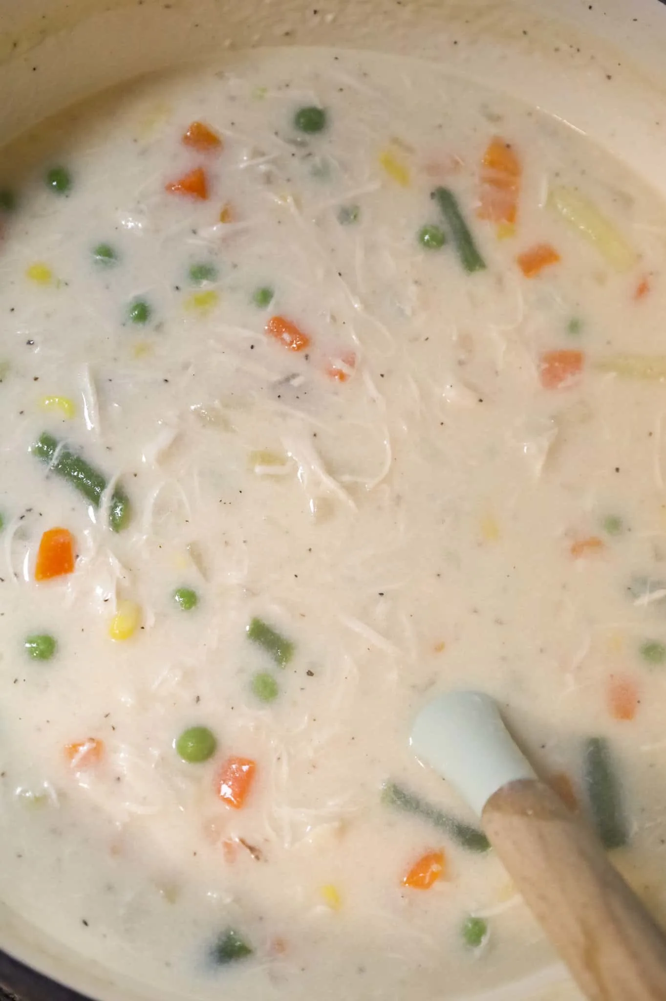 stirring vegetables and shredded chicken into cream soup