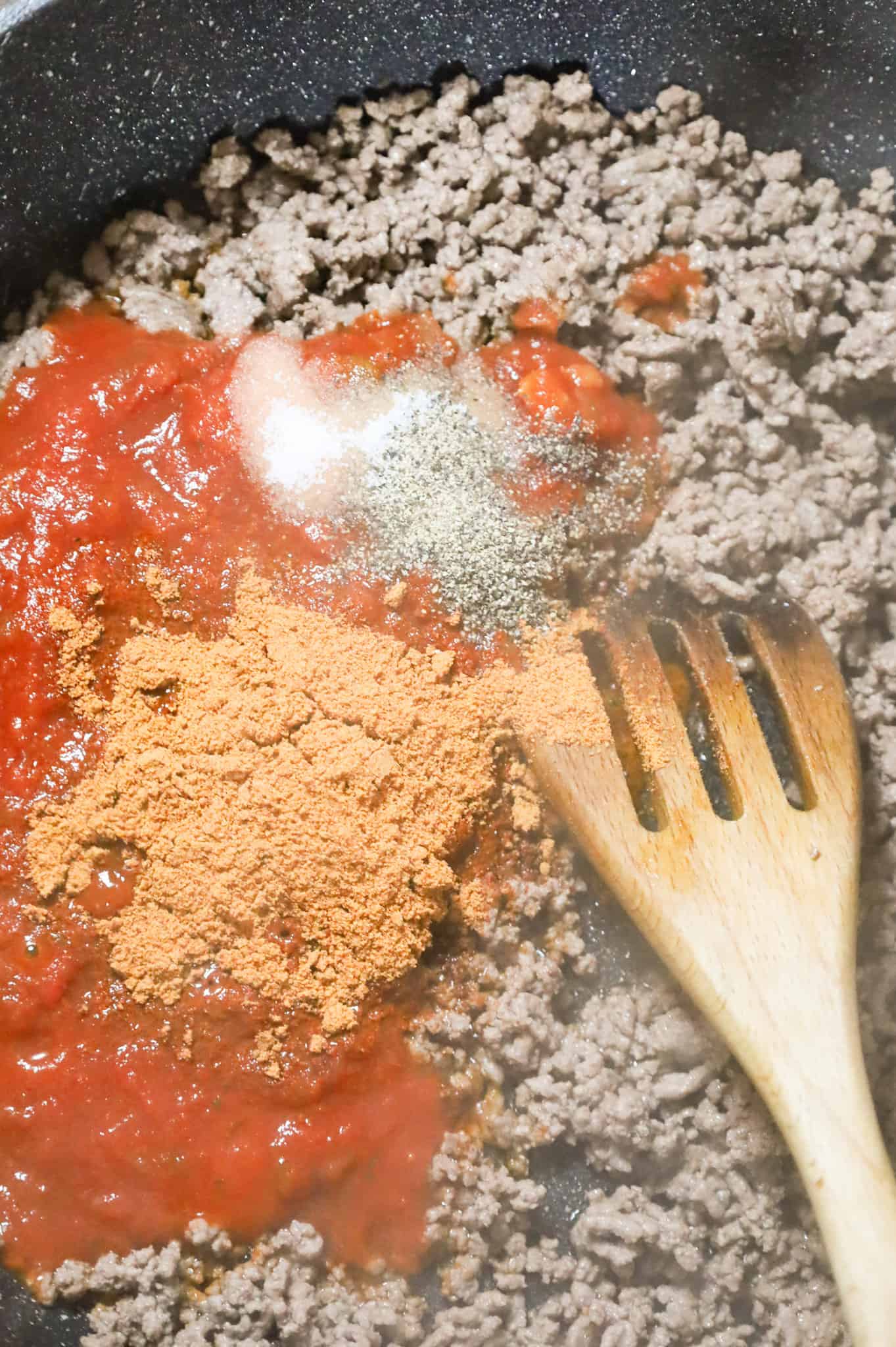 chili seasoning, salt, pepper and salsa on top of cooked ground beef in skillet