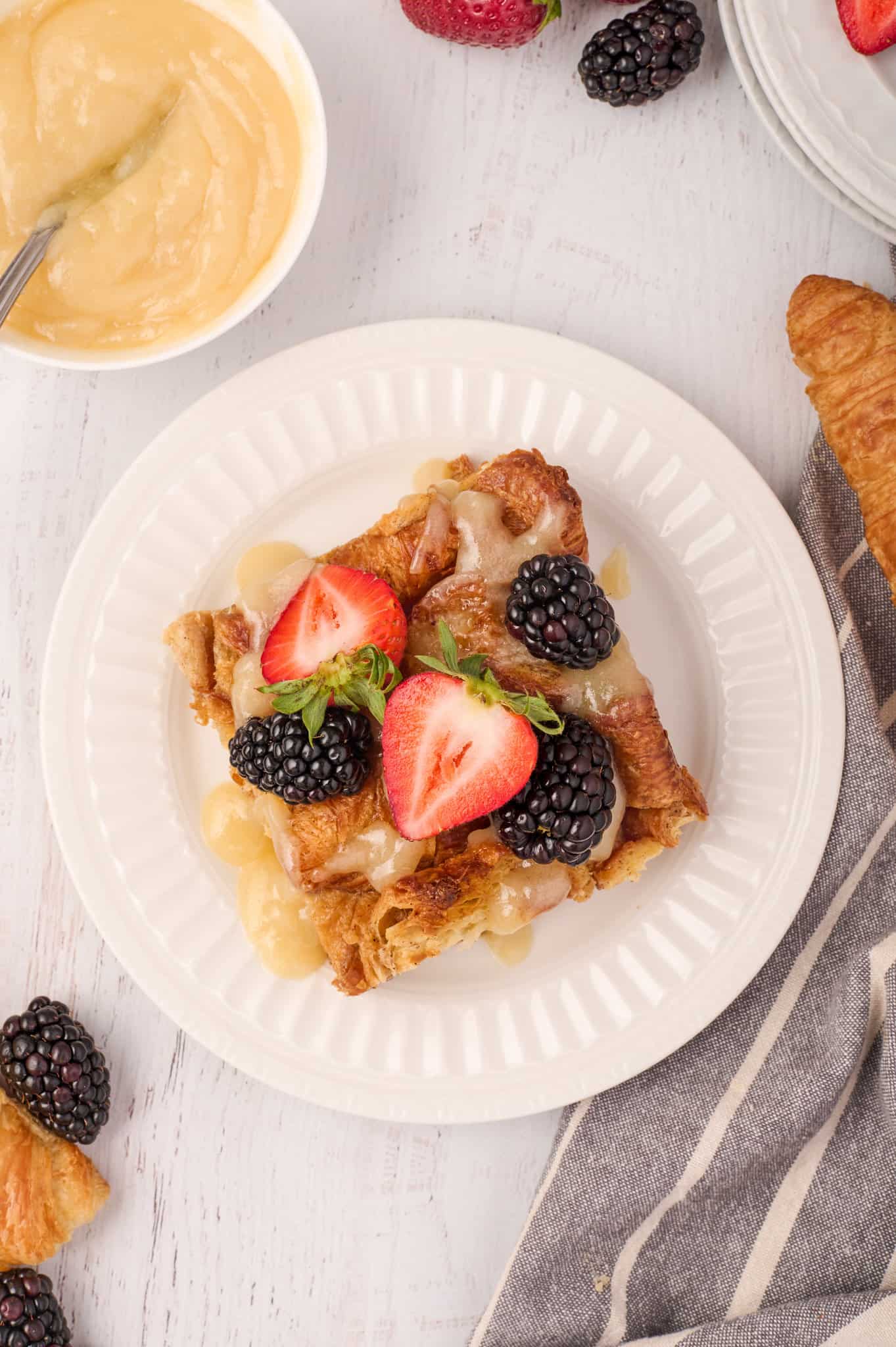 Croissant Bread Pudding is a sweet breakfast treat made with chopped butter croissants baked in an egg custard mixture and topped with a sweet vanilla sauce.