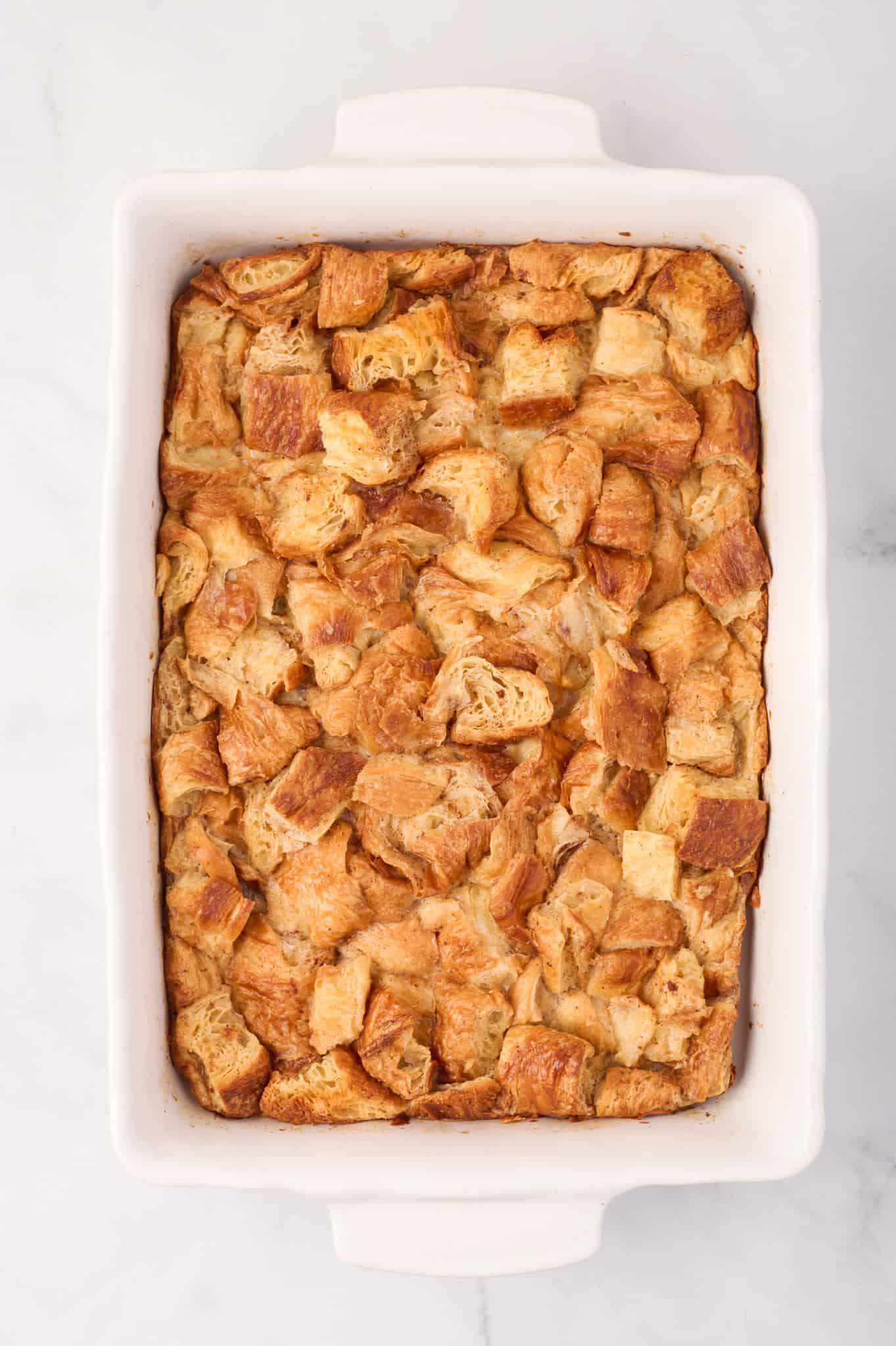 Croissant Bread Pudding is a sweet breakfast treat made with chopped butter croissants baked in an egg custard mixture and topped with a sweet vanilla sauce.