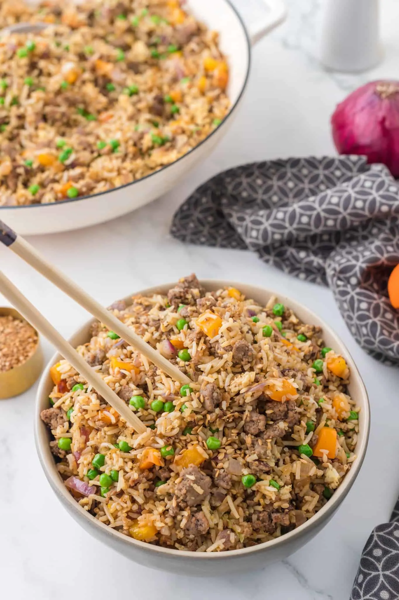 Ground Beef Fried Rice is an easy dinner recipe made with long grain rice and loaded with ground beef, diced bell peppers, peas, sesame seeds and eggs.