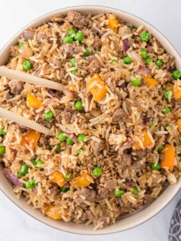 Ground Beef Fried Rice is an easy dinner recipe made with long grain rice and loaded with ground beef, diced bell peppers, peas, sesame seeds and eggs.