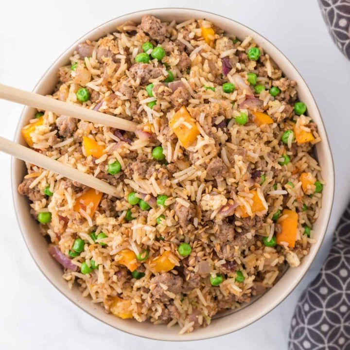 Ground Beef Fried Rice is an easy dinner recipe made with long grain rice and loaded with ground beef, diced bell peppers, peas, sesame seeds and eggs.