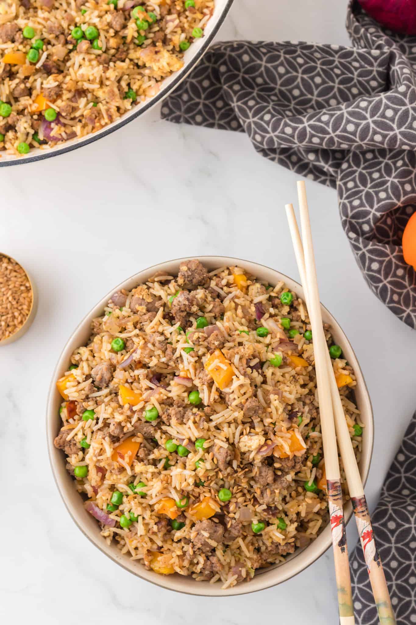 Ground Beef Fried Rice is an easy dinner recipe made with long grain rice and loaded with ground beef, diced bell peppers, peas, sesame seeds and eggs.