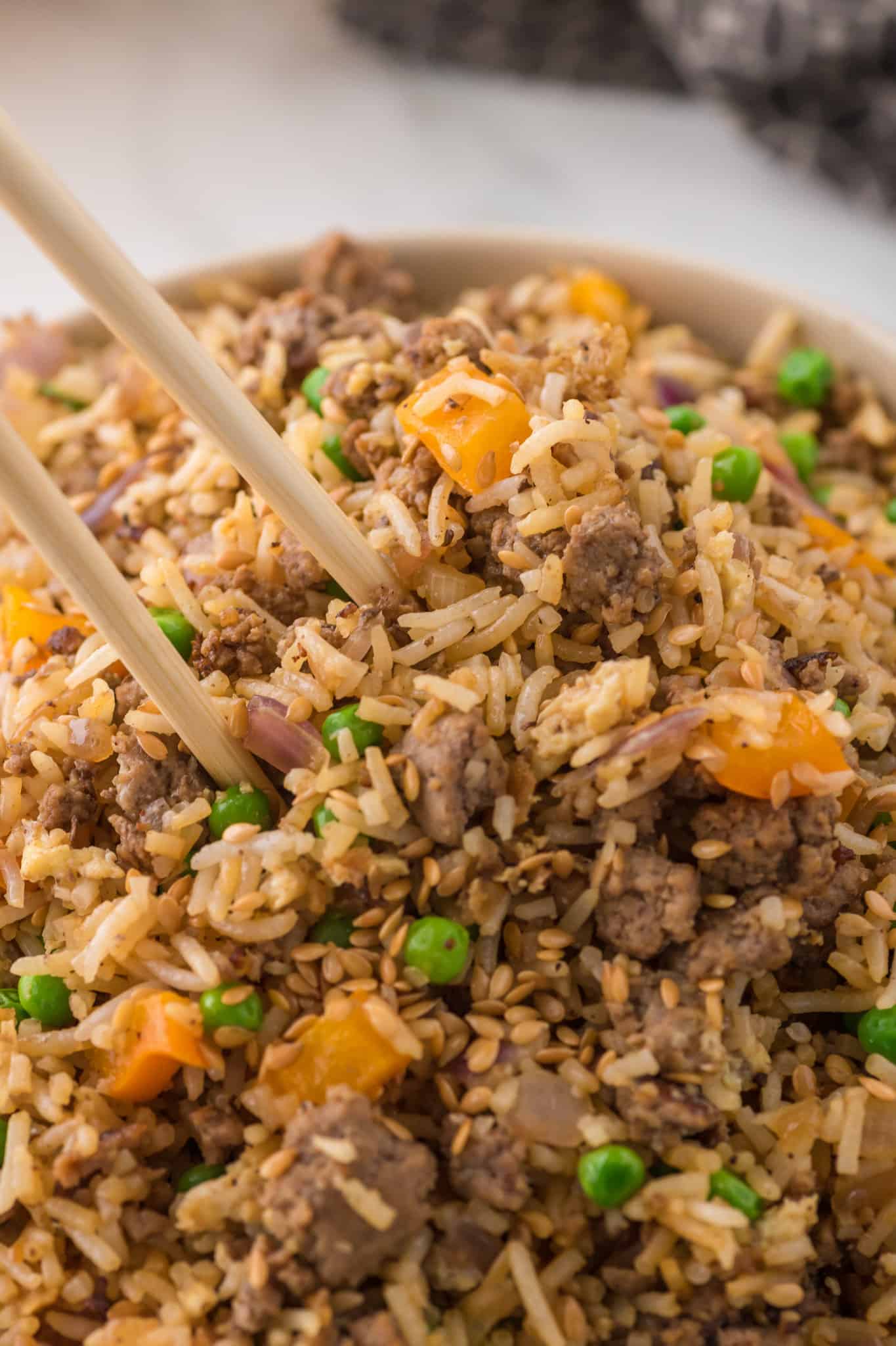 Ground Beef Fried Rice is an easy dinner recipe made with long grain rice and loaded with ground beef, diced bell peppers, peas, sesame seeds and eggs.