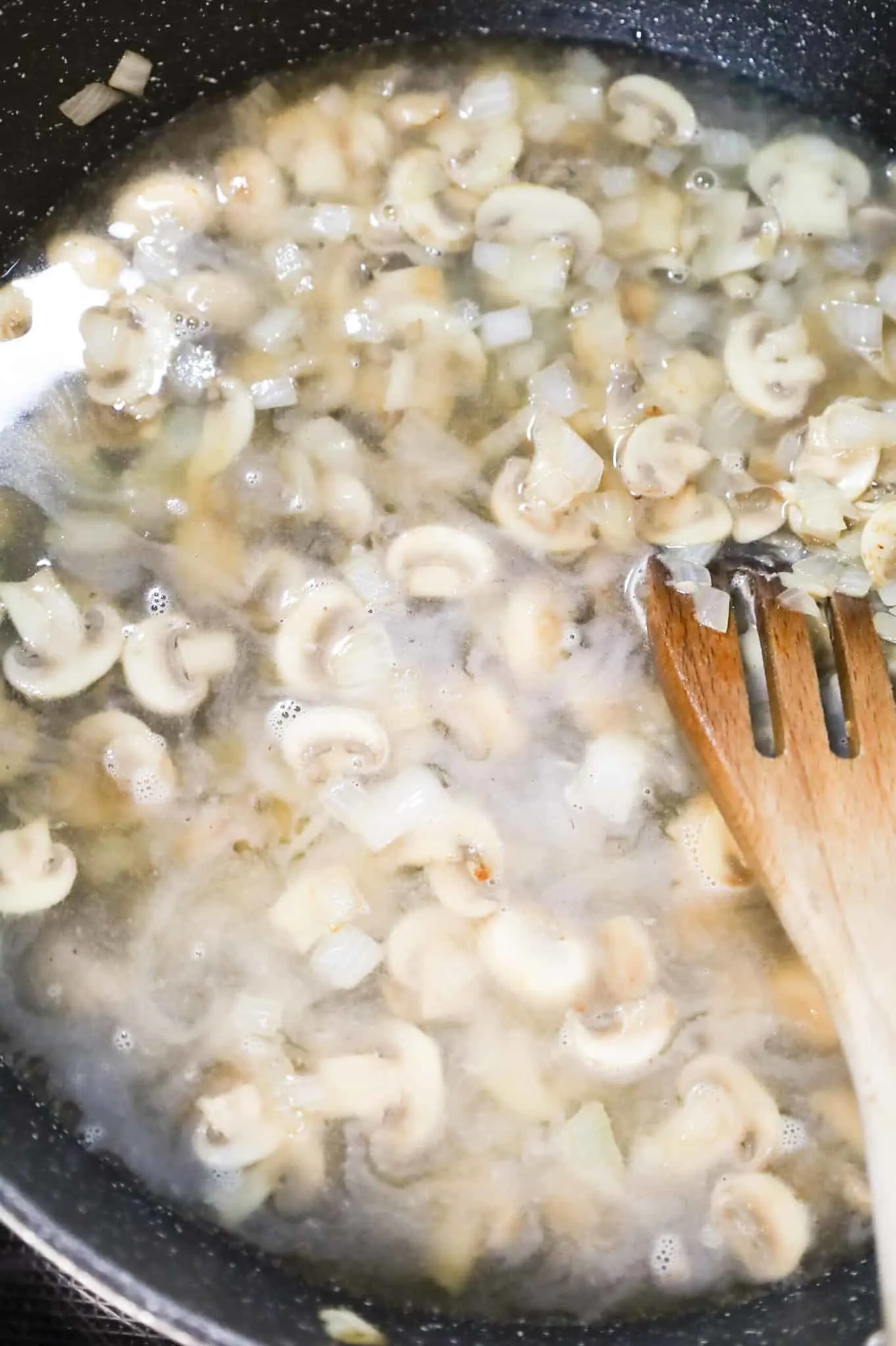 water added to skillet with sliced mushrooms and diced onions