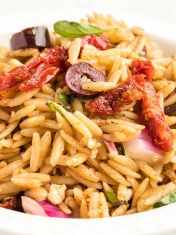 Mediterranean Orzo Pasta Salad is a delicious pasta loaded with sun dried tomatoes, red onions, Kalamata olives and feta cheese all tossed in a honey Dijon balsamic dressing.