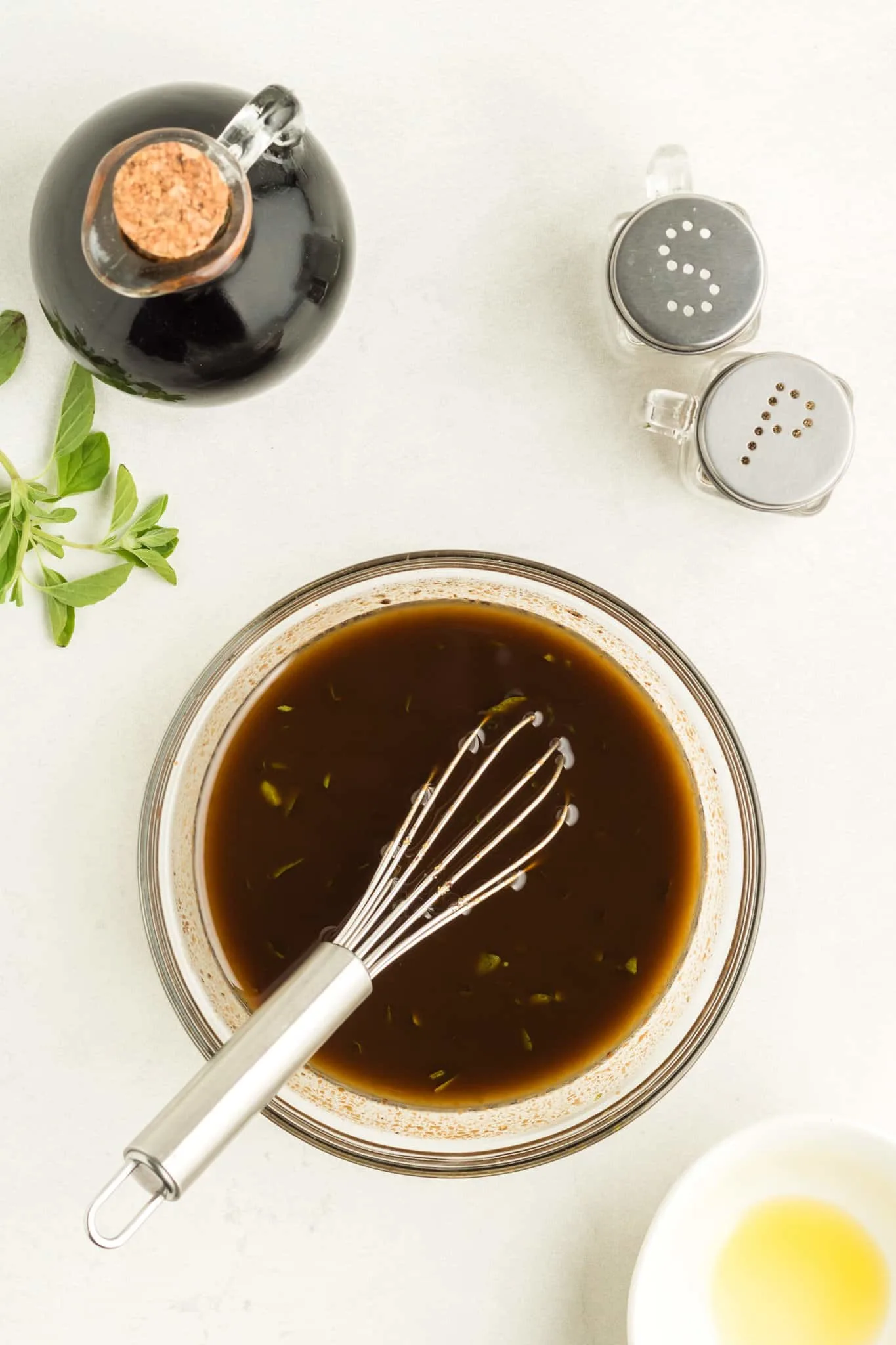 whisking oil into balsamic dressing mixture in a bowl