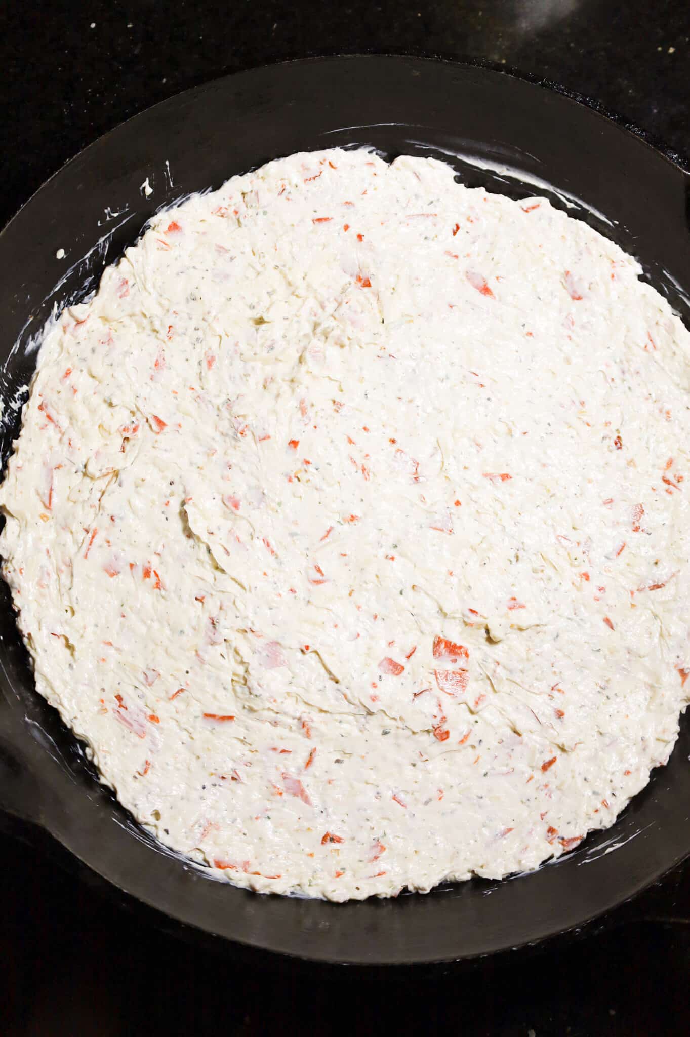 cream cheese, ranch dressing and pepperoni mixture in the bottom of a cast iron skillet.