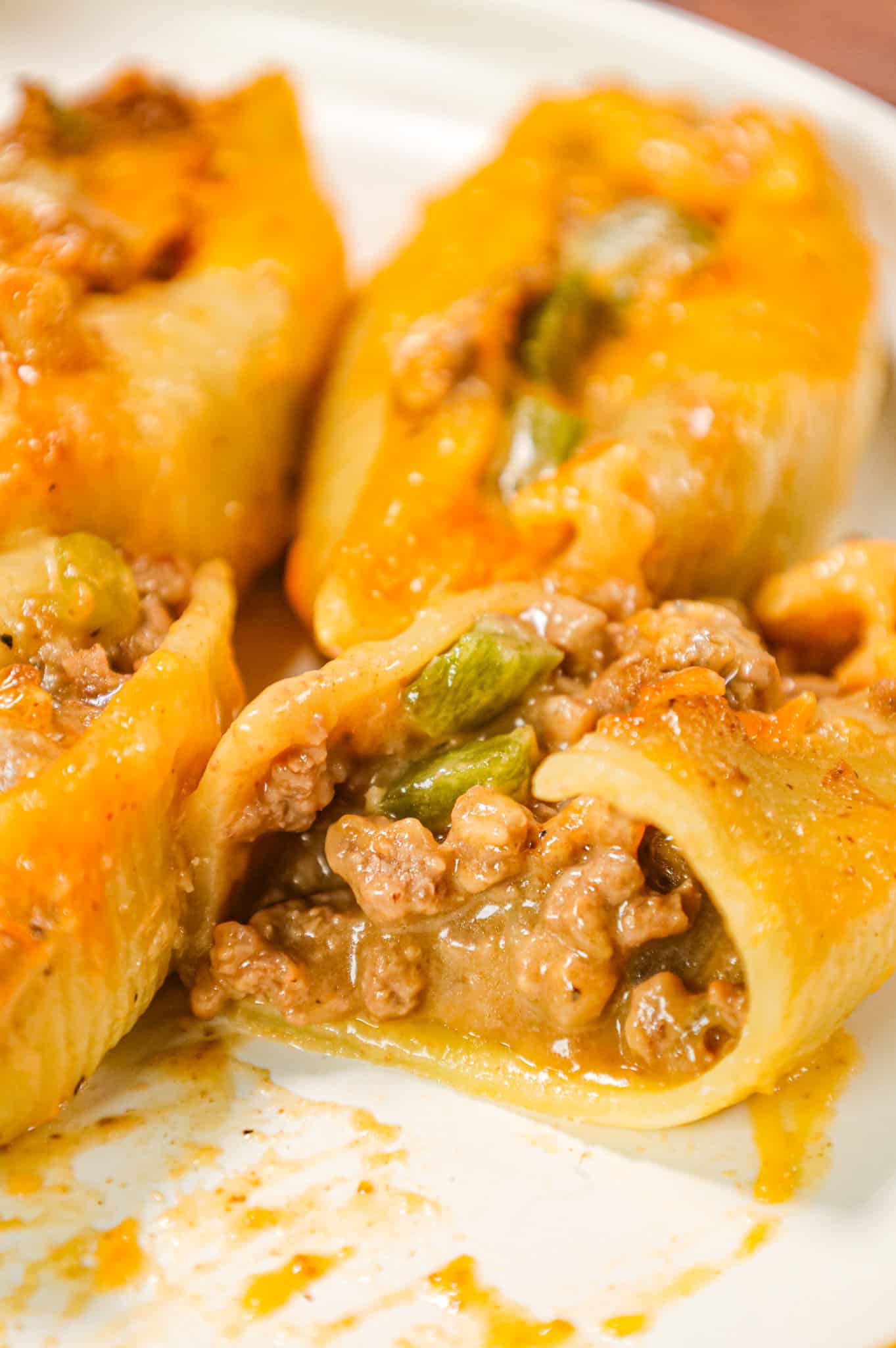 Philly Cheese Steak Stuffed Shells are a hearty pasta recipe loaded with ground beef, diced onions, green peppers, brown gravy mix, cheddar soup and shredded cheddar cheese.