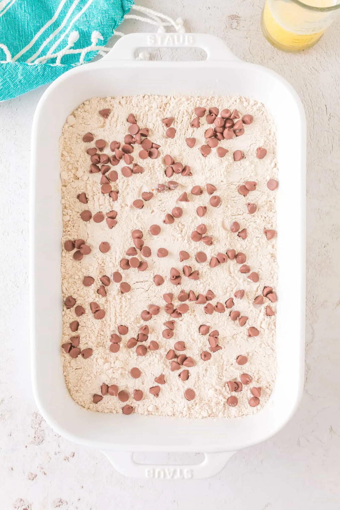 milk chocolate chips on top of spice cake mix in a baking dish