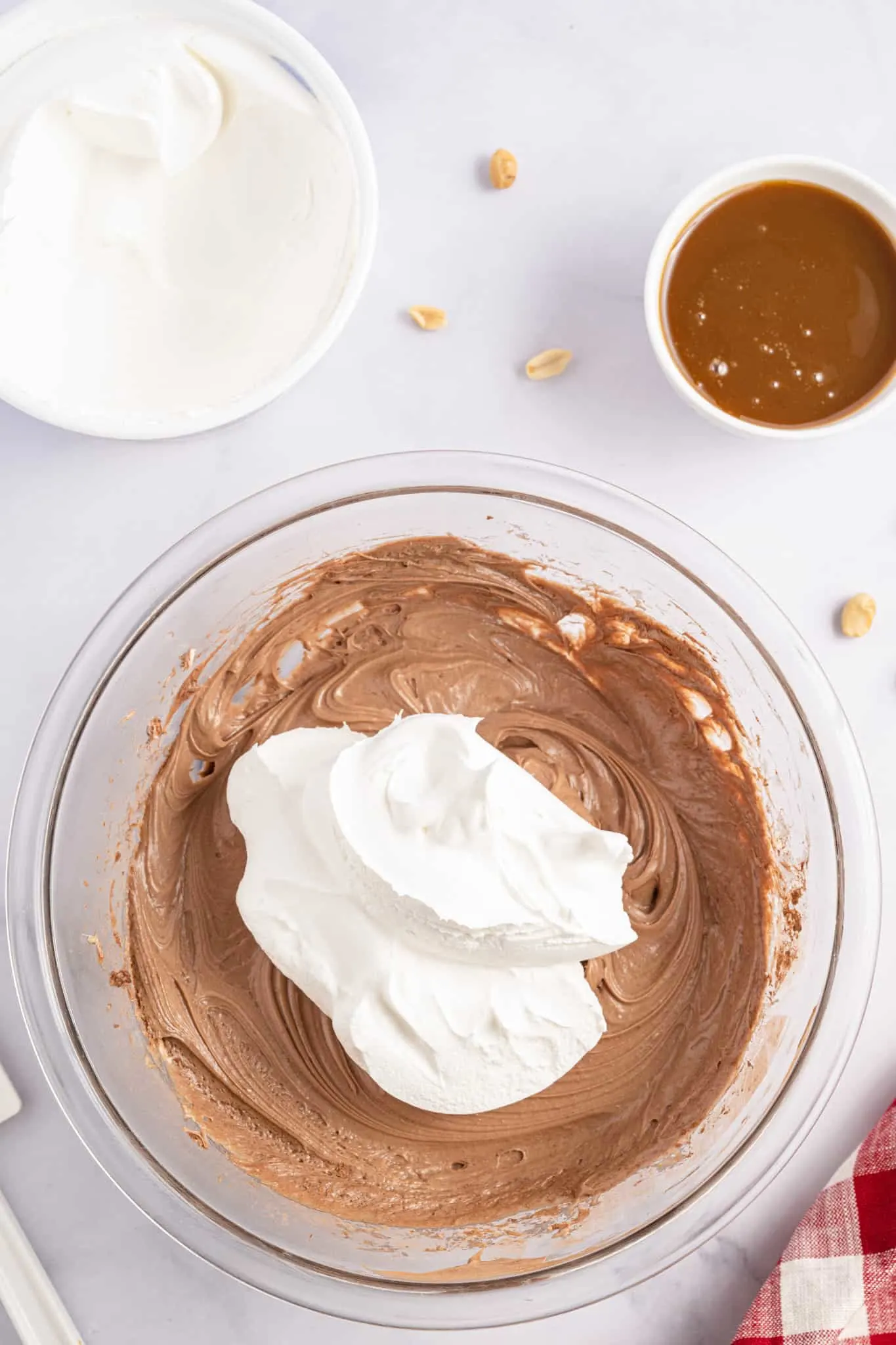 Cool Whip on top of chocolate cream cheese and sugar mixture in a mixing bowl