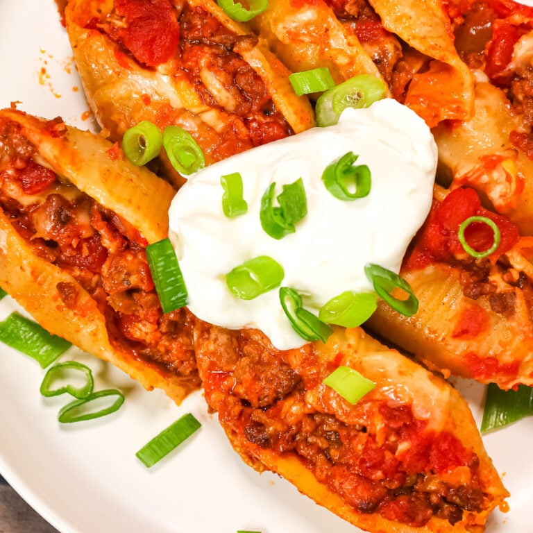 Taco Stuffed Shells are cheesy ground beef stuffed pasta shells loaded with salsa and Rotel diced tomatoes and green chilies.