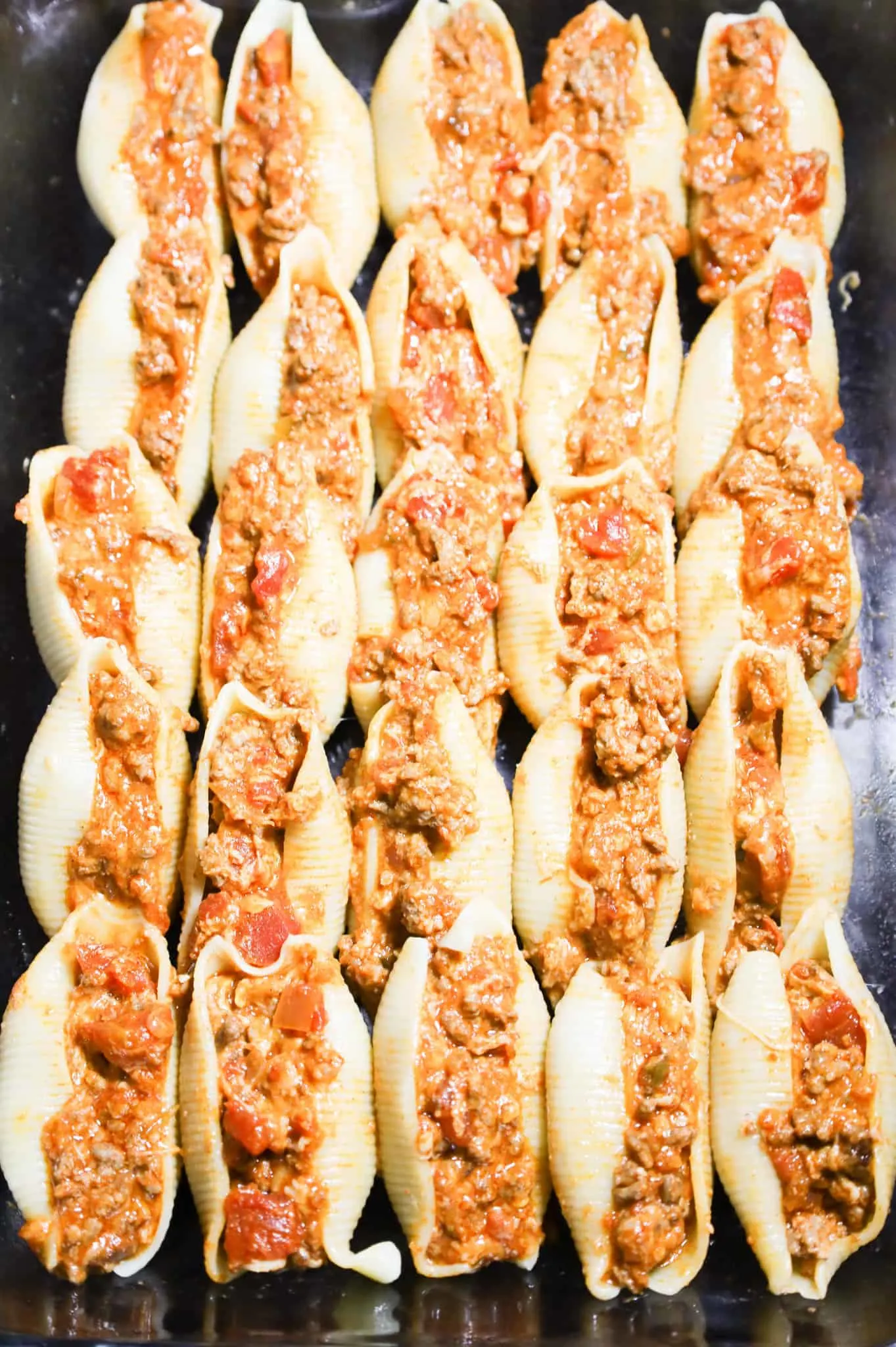 pasta shells in a baking dish stuffed with a cheesy ground beef mixture.