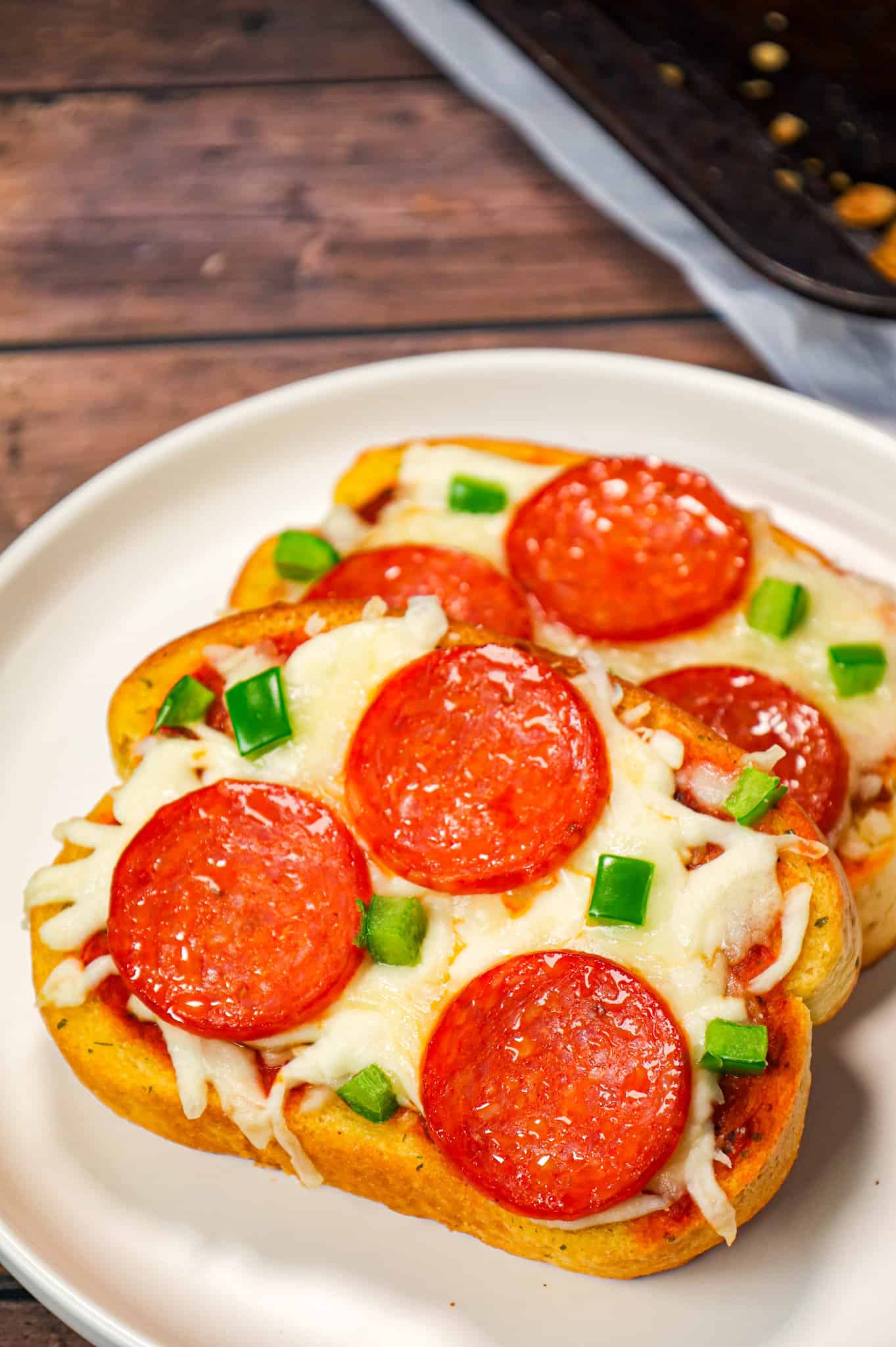 Texas Toast Pizza is an easy weeknight dinner recipe using frozen Texas toast garlic bread and topped with pizza sauce, shredded mozzarella cheese, pepperoni slices and green peppers.