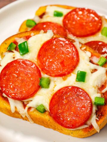 Texas Toast Pizza is an easy weeknight dinner recipe using frozen Texas toast garlic bread and topped with pizza sauce, shredded mozzarella cheese, pepperoni slices and green peppers.