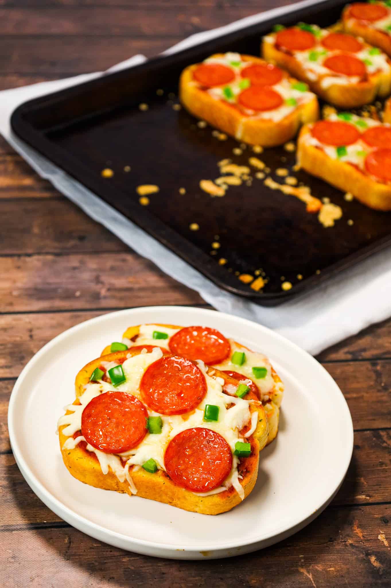 Texas Toast Pizza is an easy weeknight dinner recipe using frozen Texas toast garlic bread and topped with pizza sauce, shredded mozzarella cheese, pepperoni slices and green peppers.