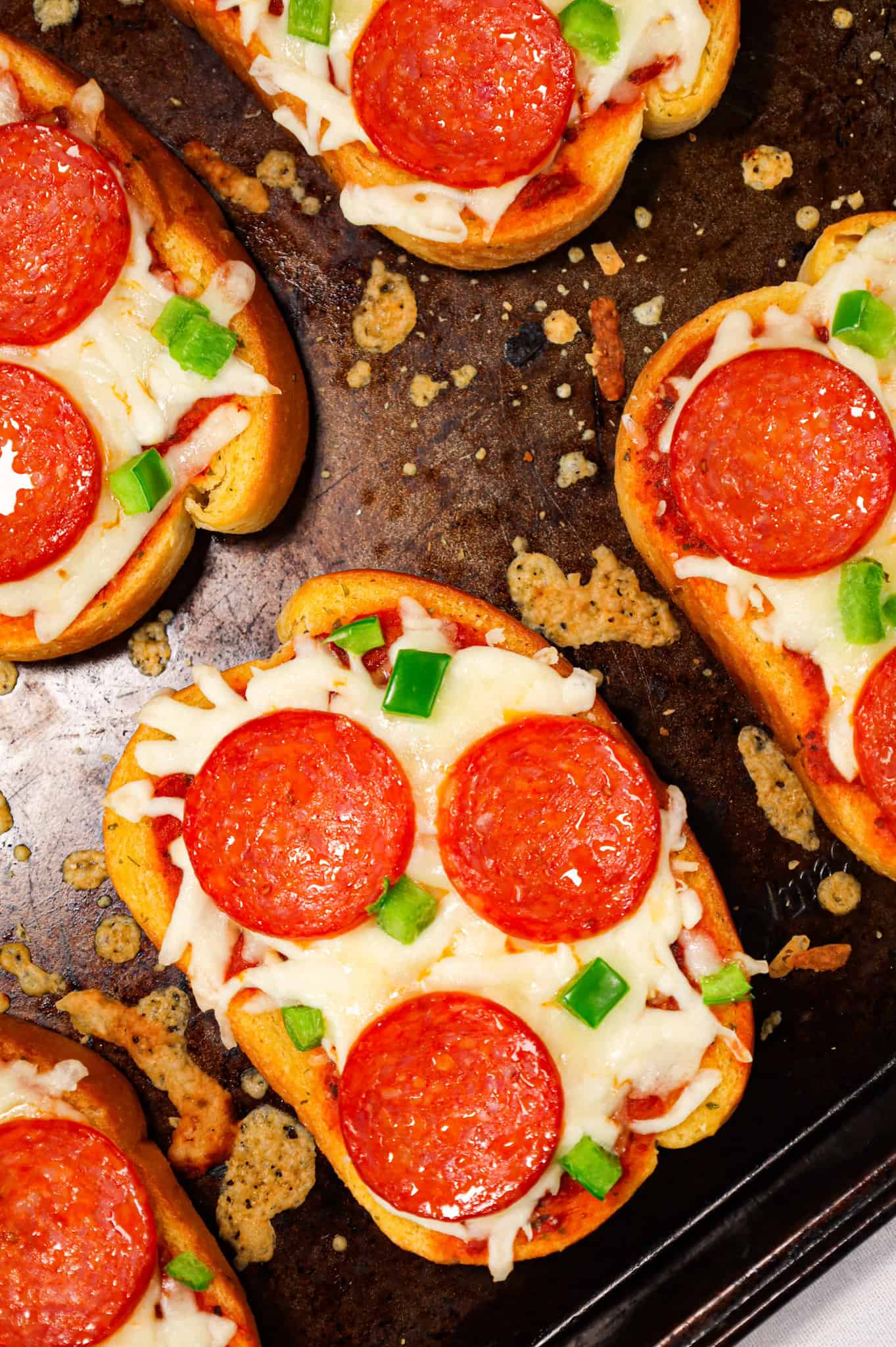 Texas Toast Pizza is an easy weeknight dinner recipe using frozen Texas toast garlic bread and topped with pizza sauce, shredded mozzarella cheese, pepperoni slices and green peppers.