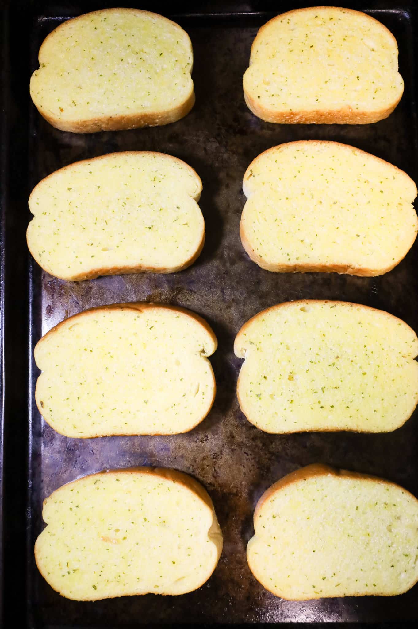 garlic texas toast slices on a baking sheet