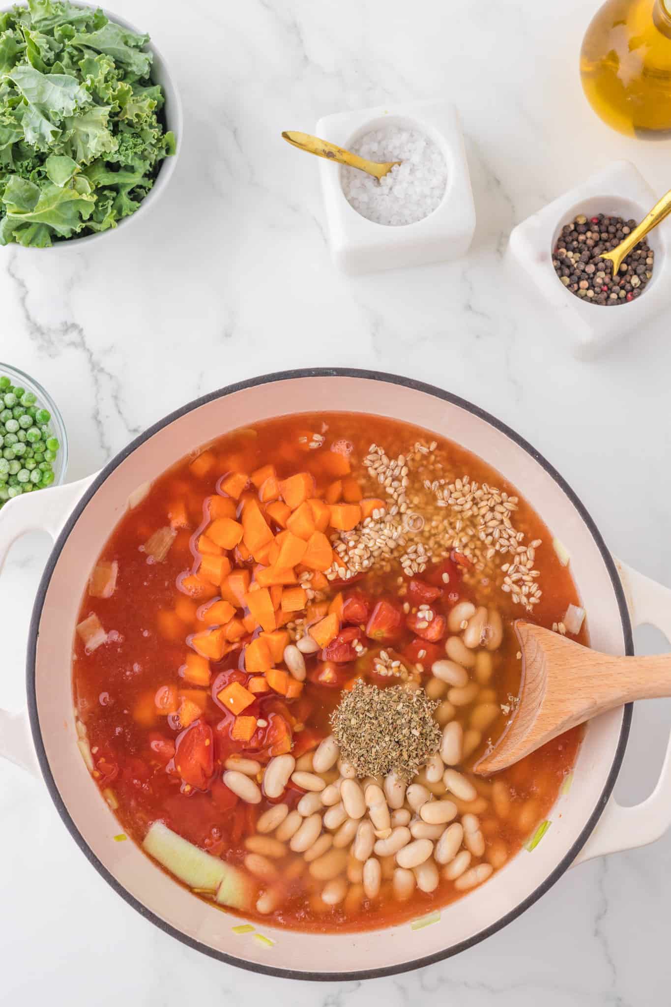diced carrots, beans, diced tomatoes, barley, spices and vegetable broth added to soup pot.