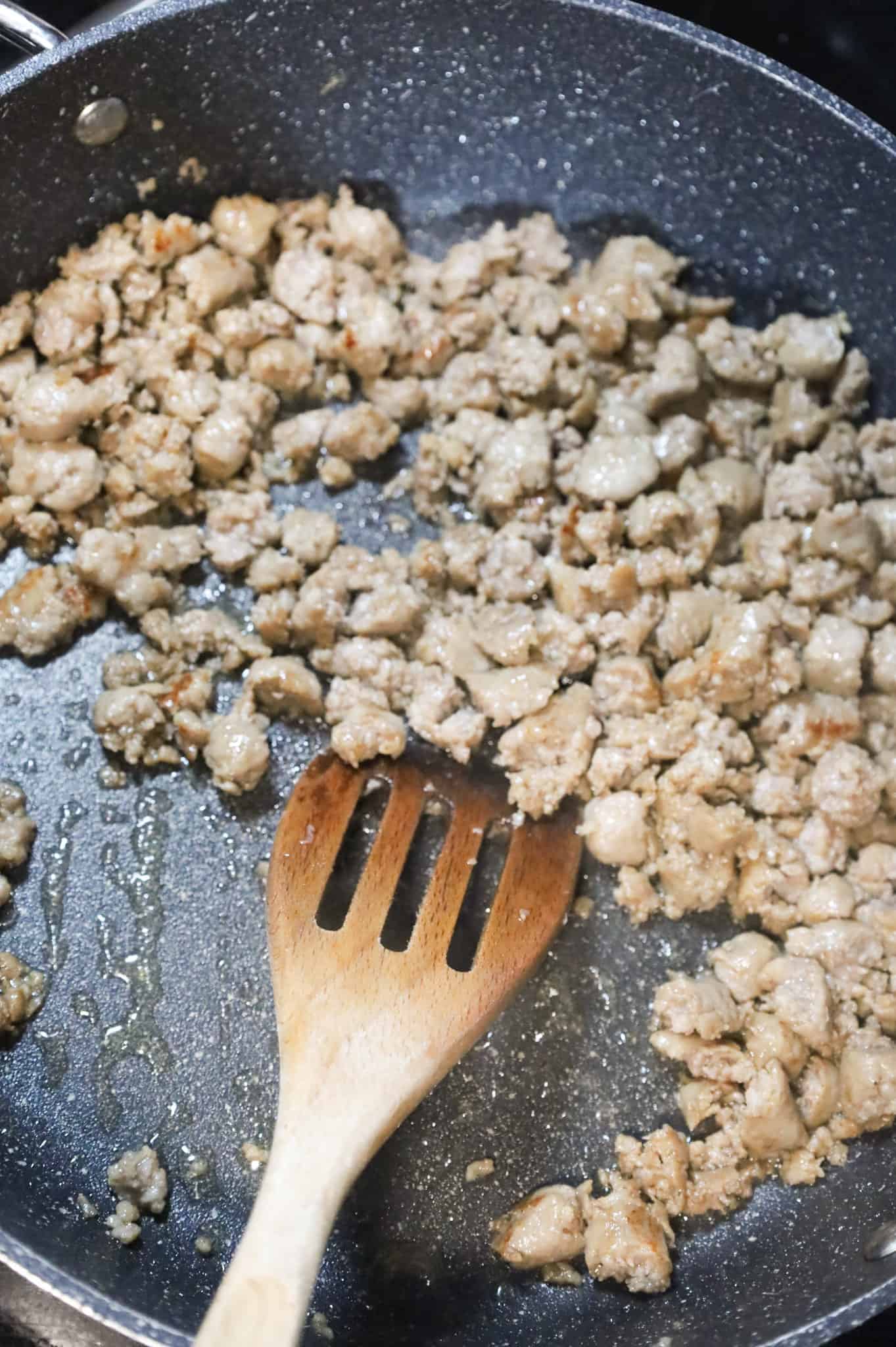 crumbled sausage cooking in a skillet