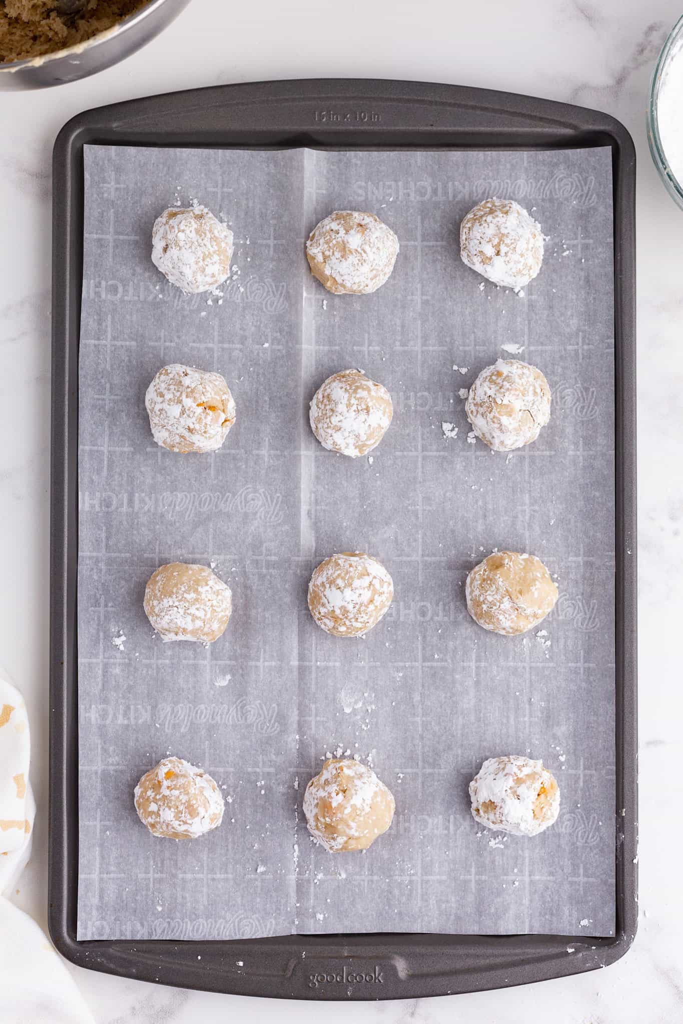 butterscotch cookie dough balls on a parchment paper lined baking sheet