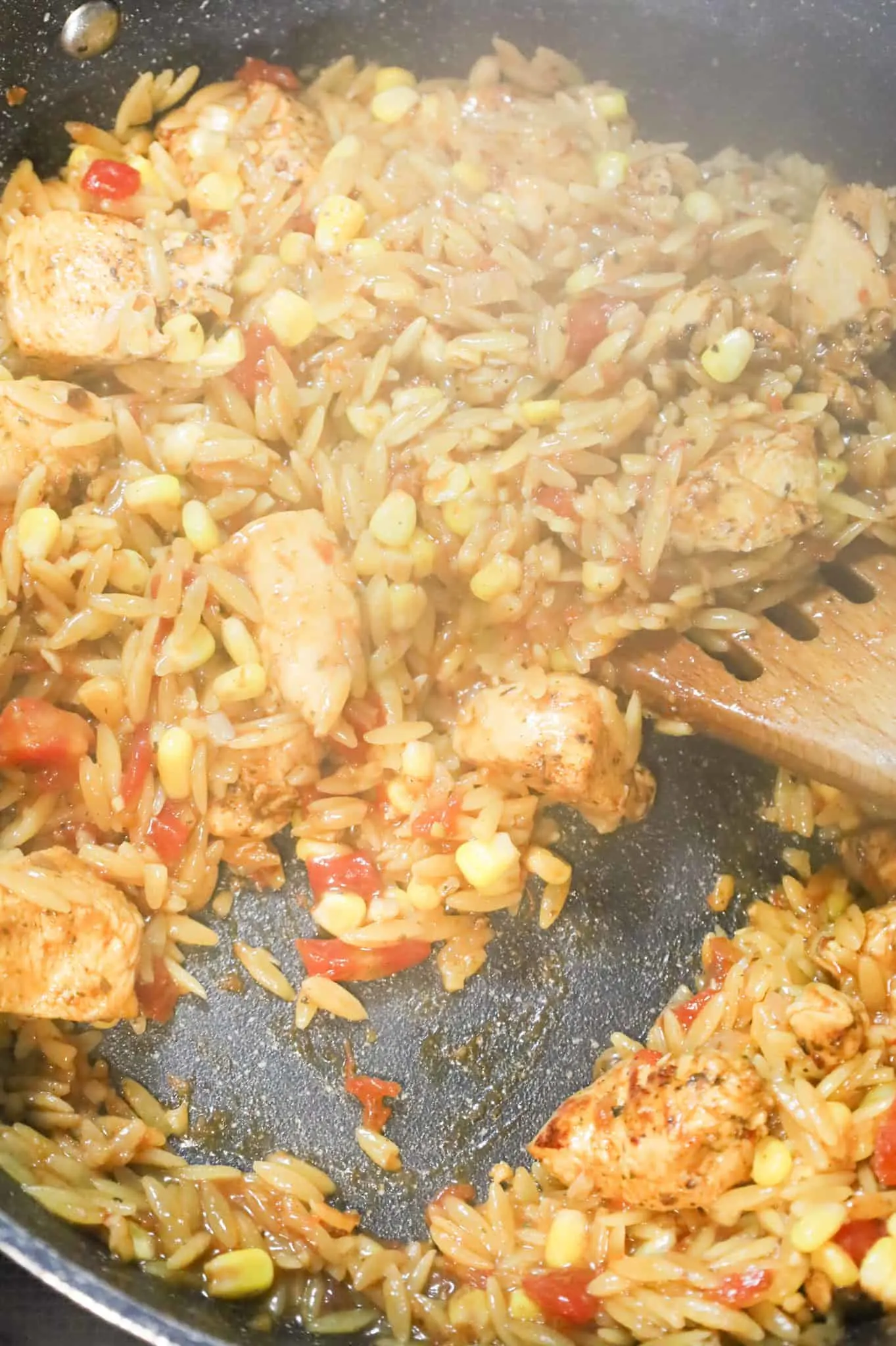Cajun orzo pasta cooking in a skillet