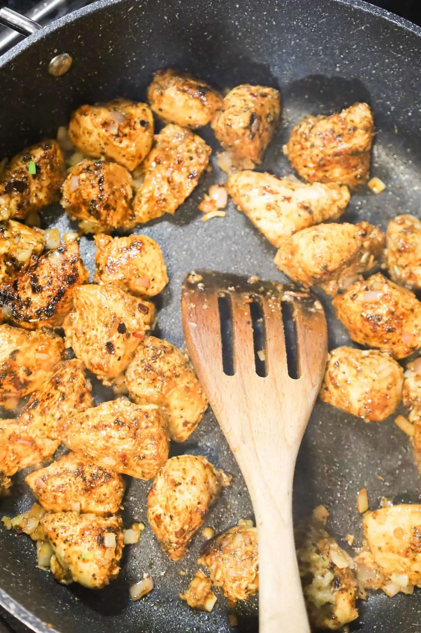 stirring together minced shallots, garlic puree and chicken breast chunks in a skillet