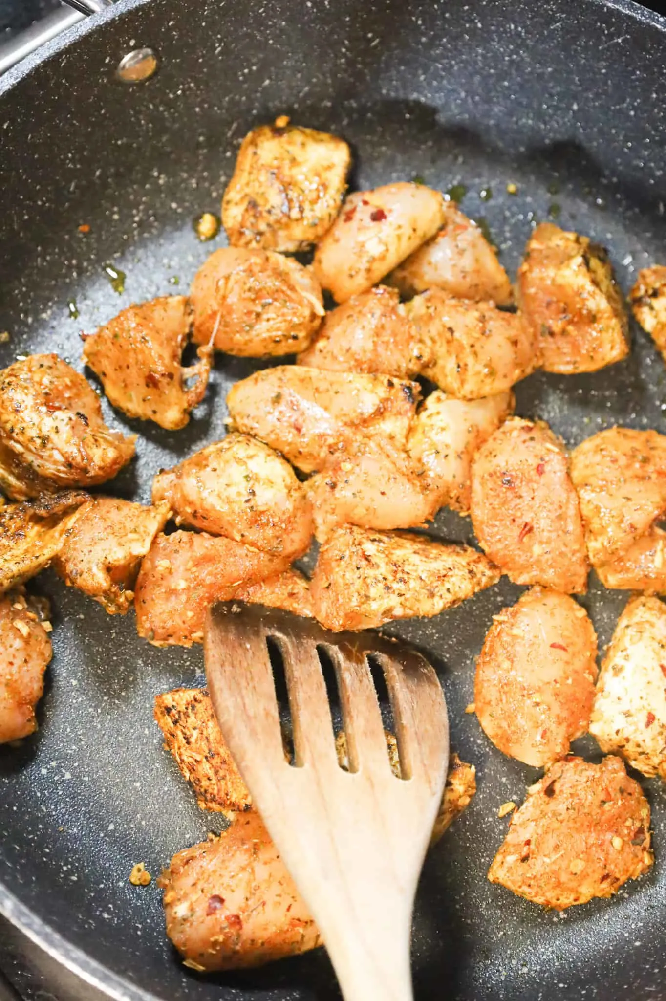 Cajun chicken breasts chunks cooking in a skillet