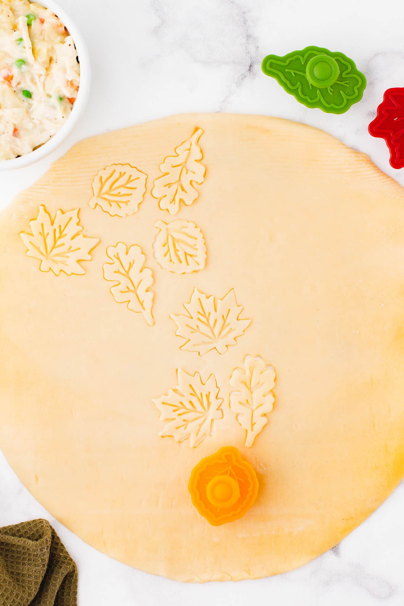 a cookie cutter cutting leaf shapes in pastry