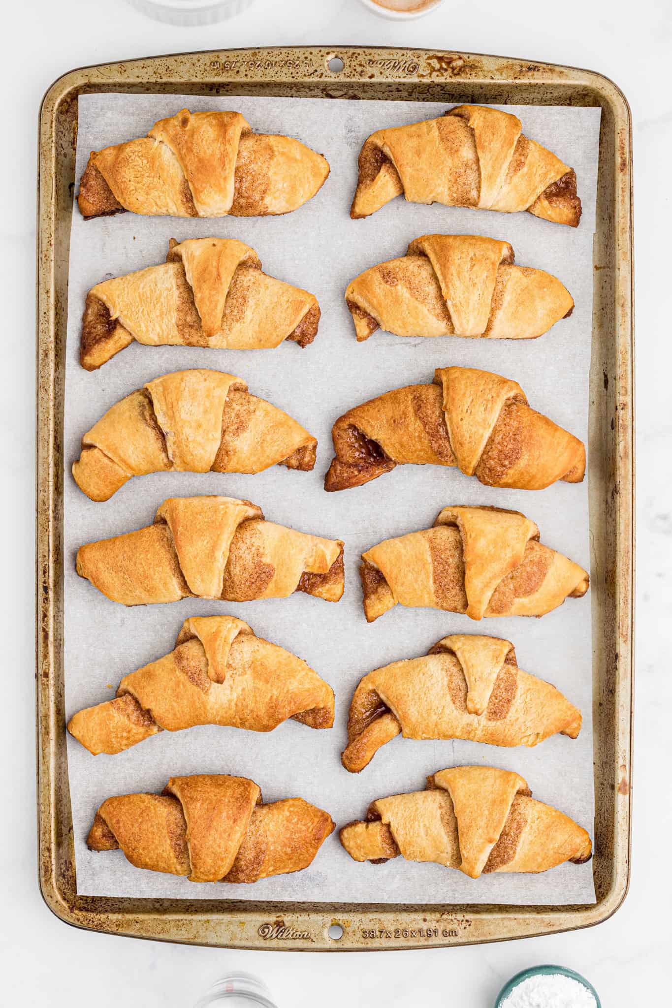 baked cinnamon crescent rolls on a parchment lined baking sheet