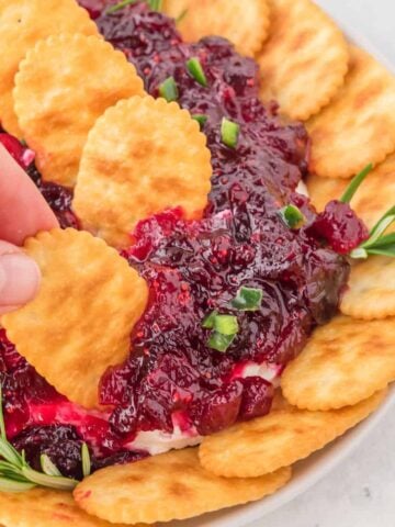 Cranberry Cream Cheese Dip is a delicious party dip recipe with a cream cheese jalapeno base topped with cranberry sauce.