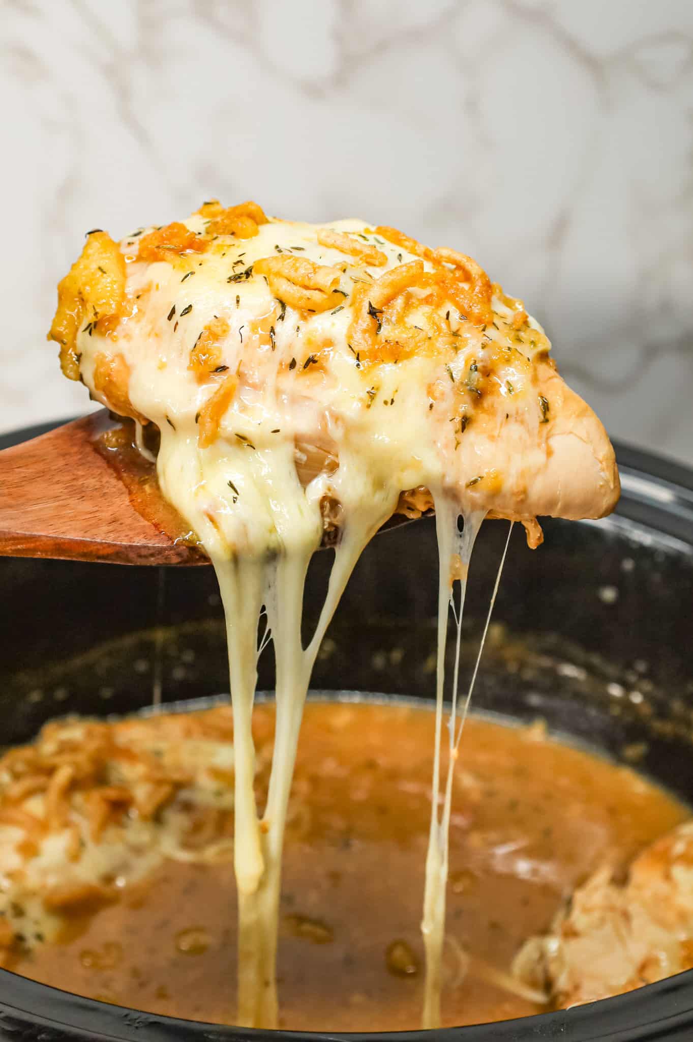 Crock Pot French Onion Chicken is an easy slow cooker chicken breasts recipe made with beef broth, onion soup mix, yellow onions, cream of chicken soup, provolone cheese and French's crispy fried onions.