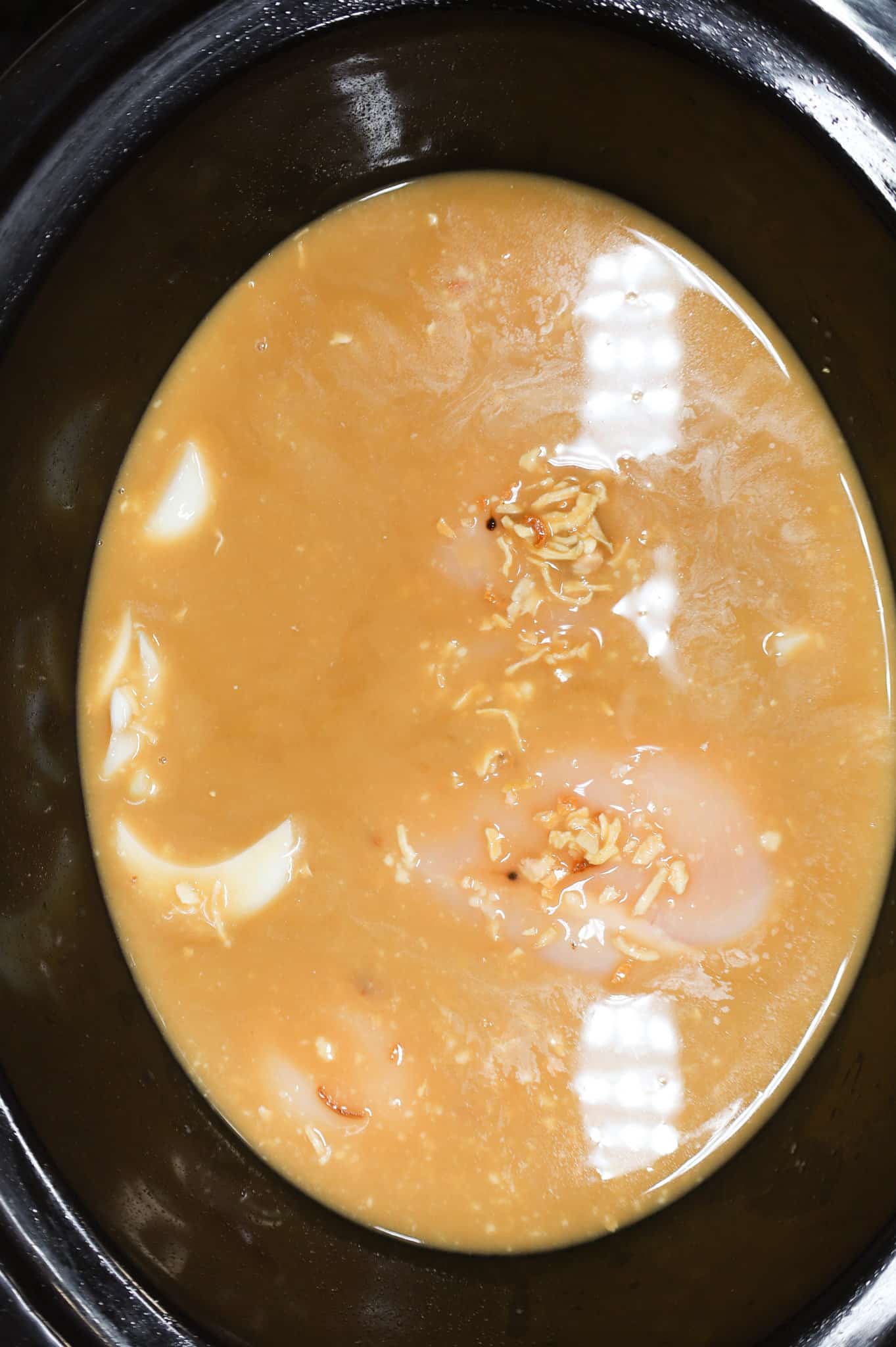 onion soup mixture poured over chicken breasts in a crock pot
