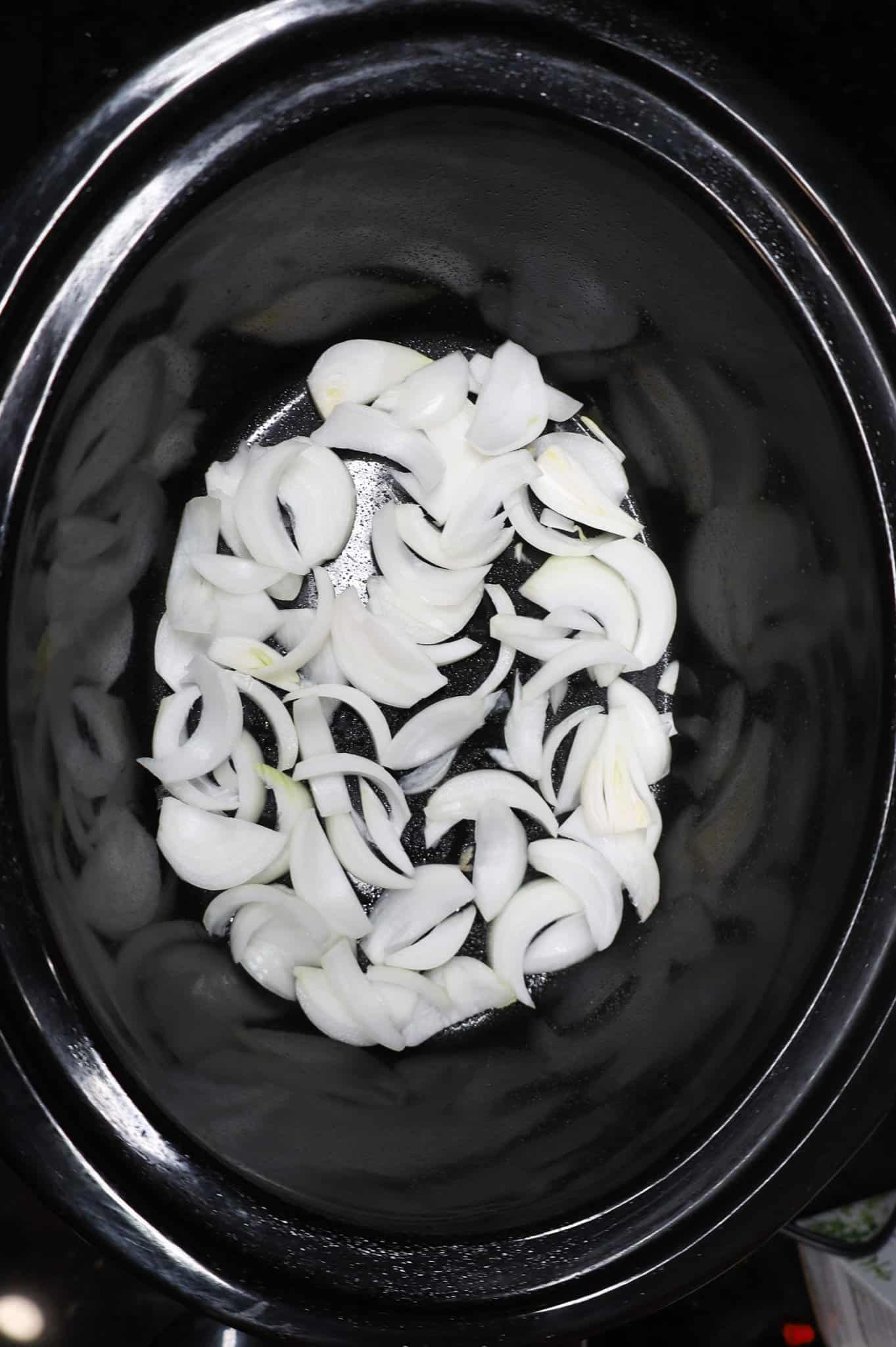 onion slices in the bottom of a crock pot