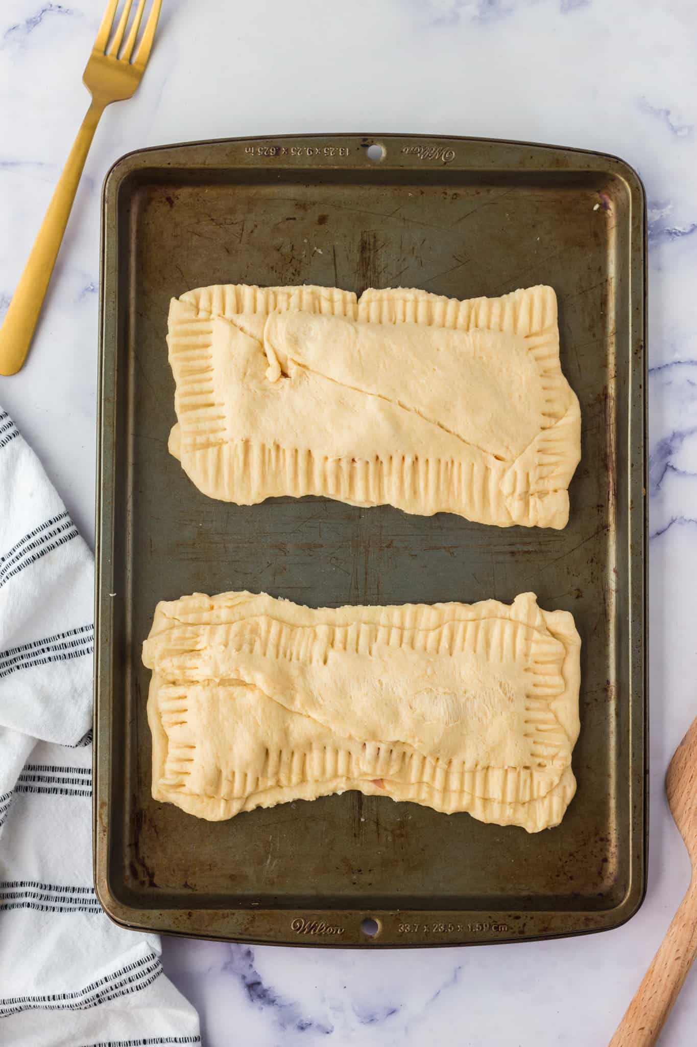 crescent dough hot pockets on a baking sheet before baking