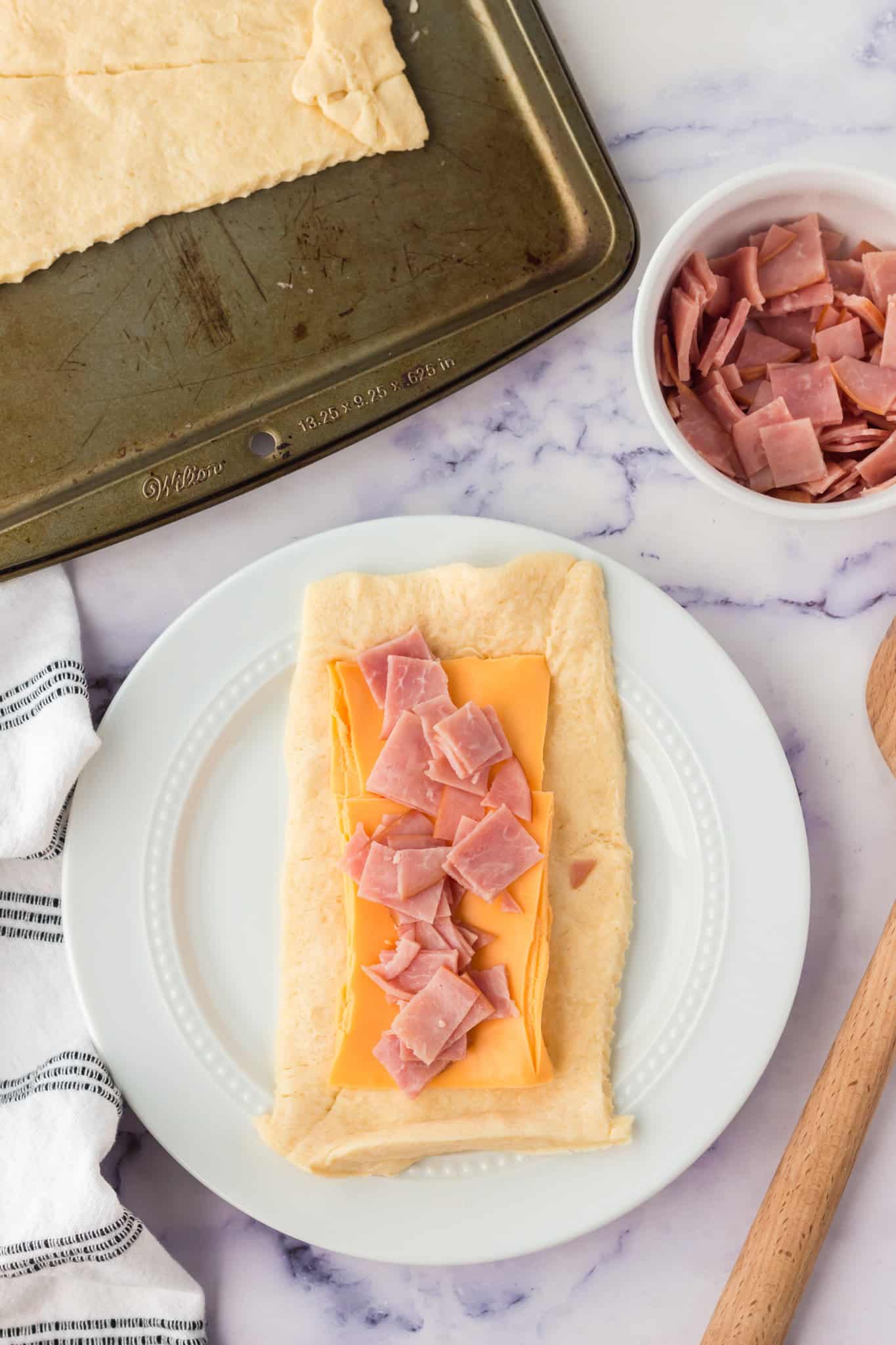 chopped ham and cheese slices on top of rectangle of crescent dough