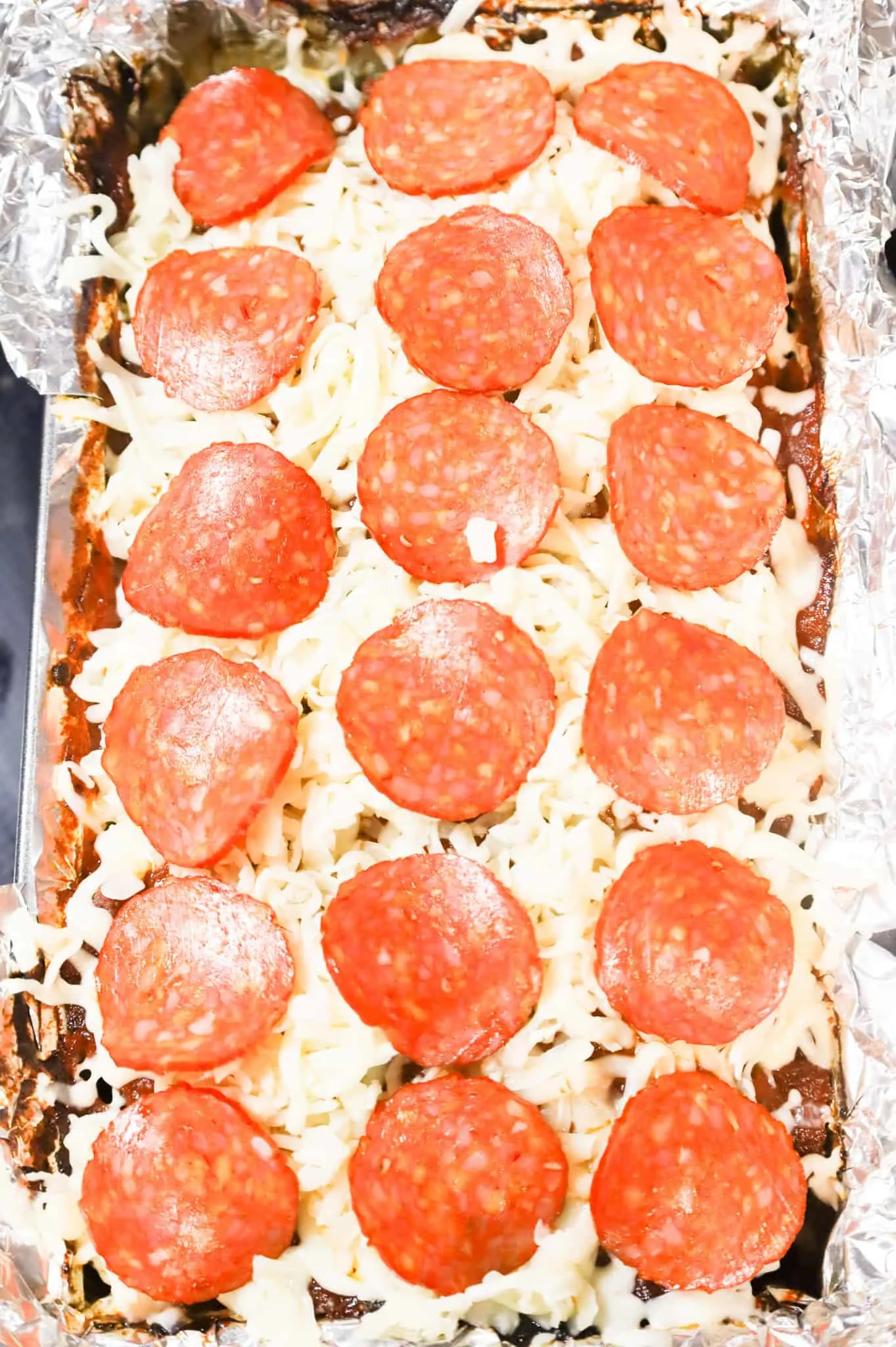 pepperoni slices on top of mozzarella cheese on a meatloaf