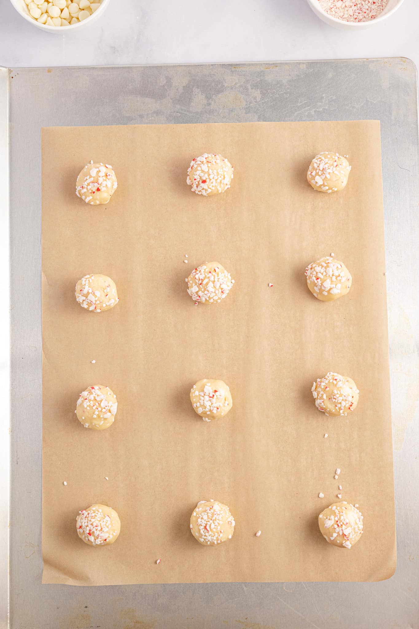 peppermint cookie dough balls on a parchment lined baking sheet