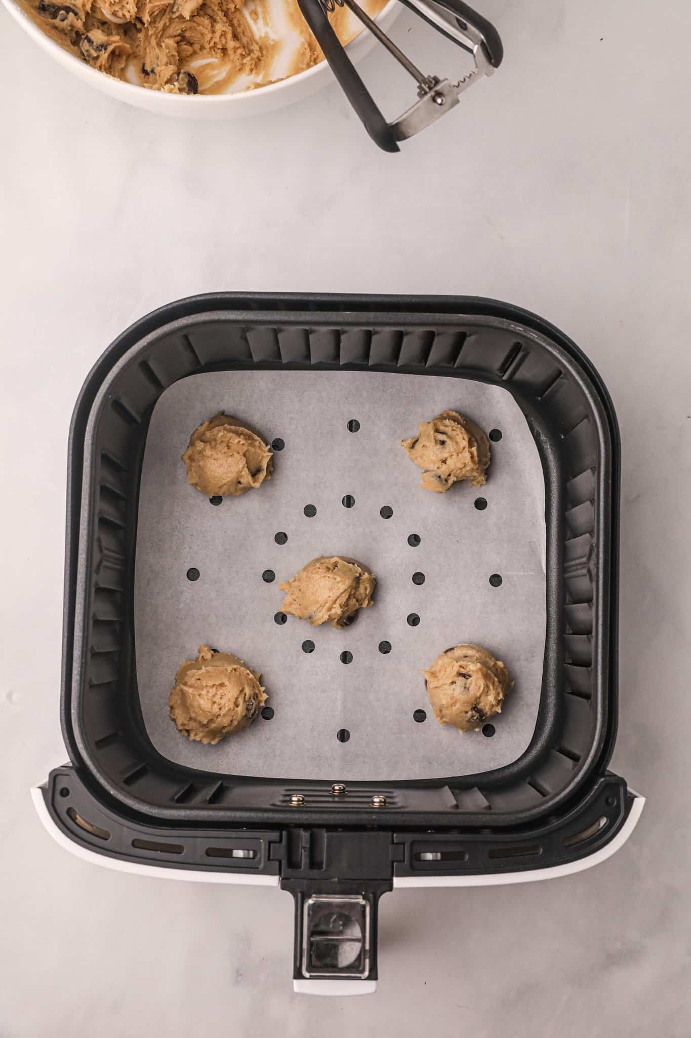 chocolate chip cookie dough balls in an air fryer basket