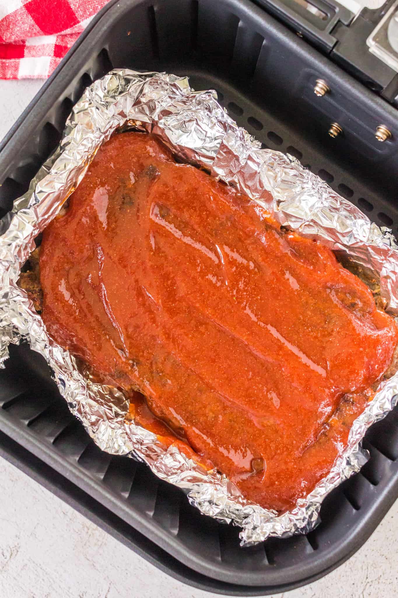 Air Fryer Meatloaf is a simple ground beef meatloaf recipe made with Italian seasoned bread crumbs and topped with a brown sugar ketchup glaze.