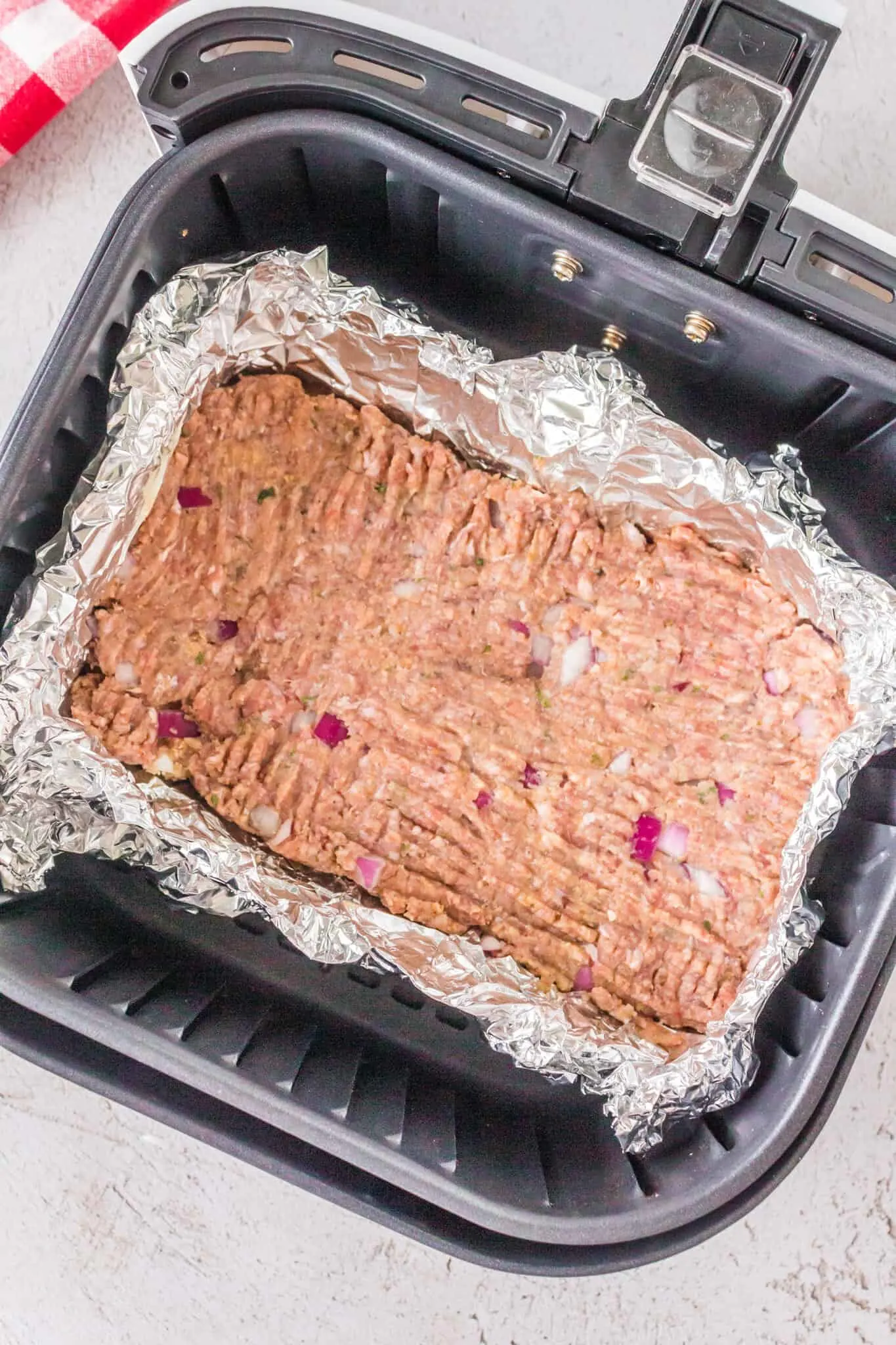 raw meatloaf in an air fryer basket