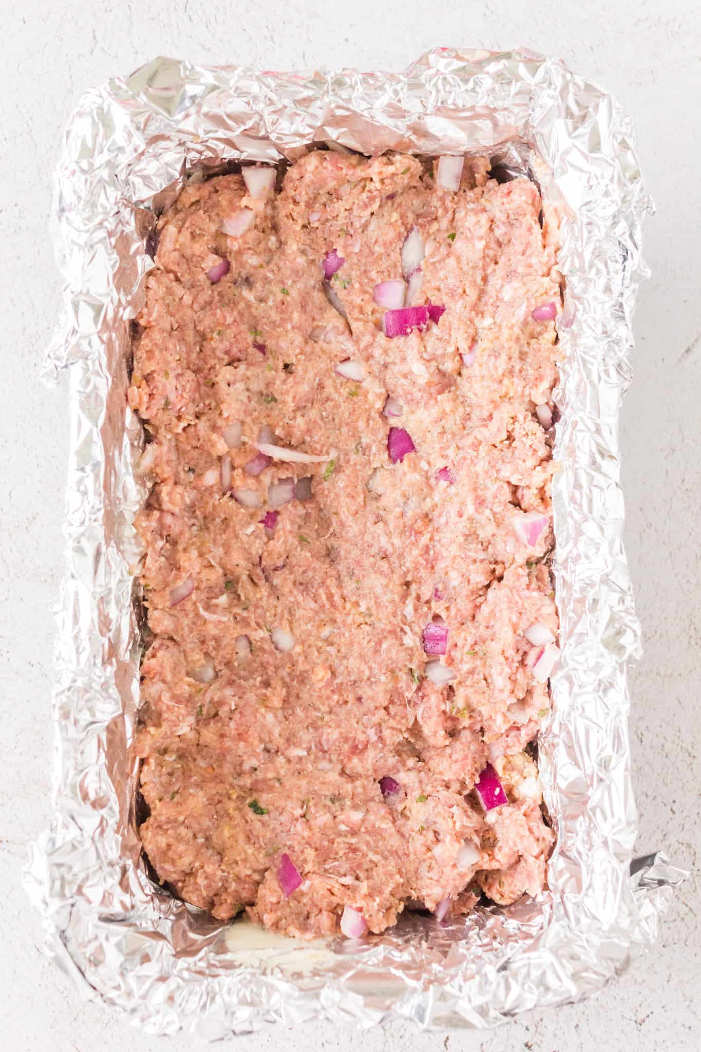 ground beef mixture in a foil lined loaf pan