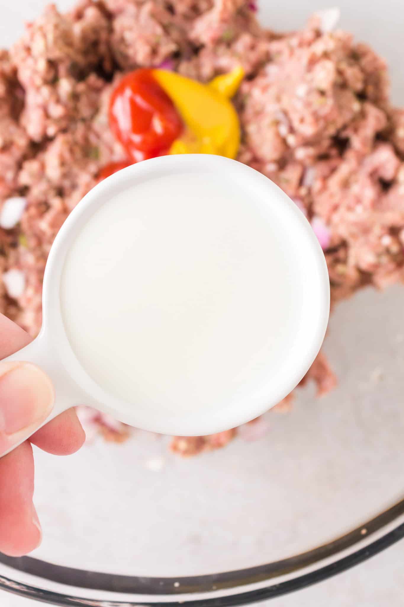 milk being added to bowl with ground beef mixture