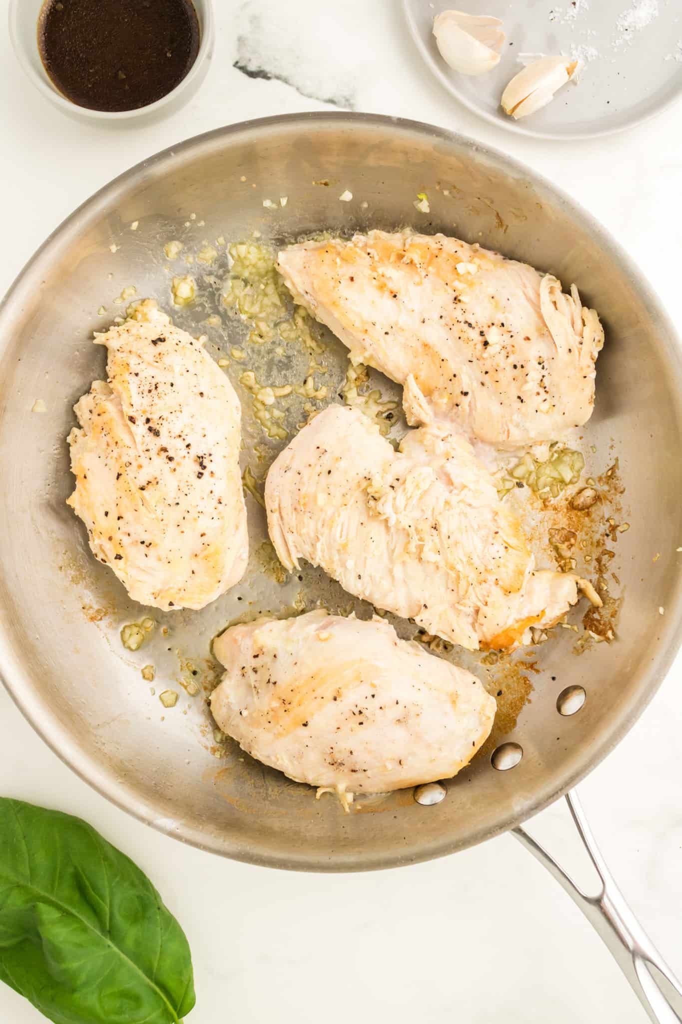 chicken breasts cooking in a skillet