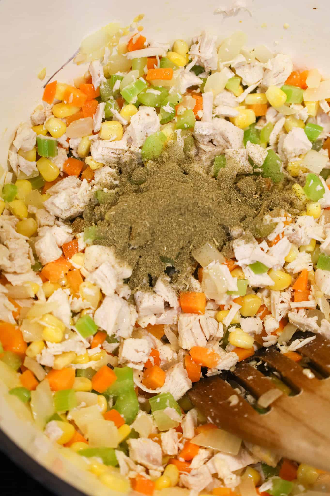 poultry seasoning added to pot with chopped chicken and veggies