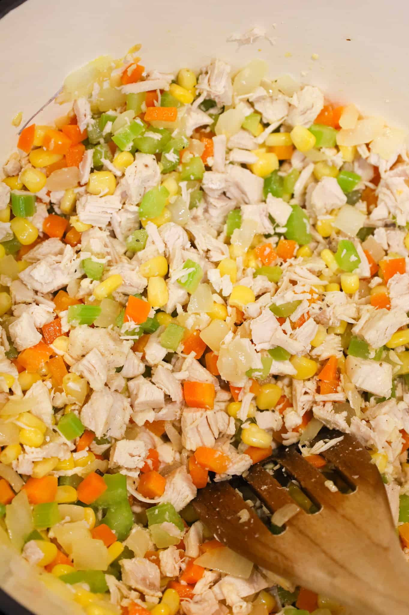 chicken and vegetable mixture being stirred in a pot