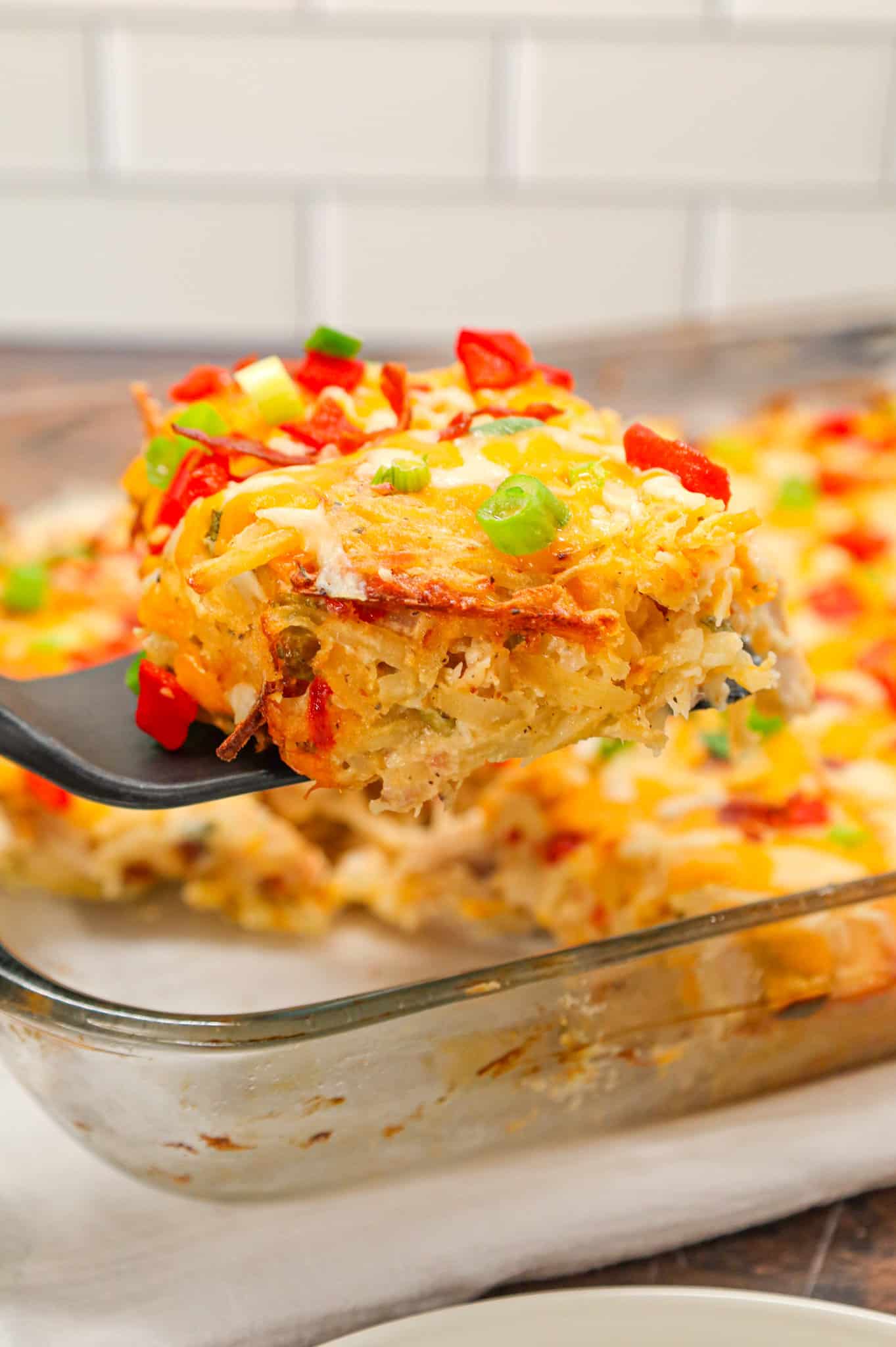 Chicken Hashbrown Casserole is a hearty dish made with shredded potatoes, shredded rotisserie chicken, crumbled bacon, roasted red peppers, cheddar cheese, ranch dressing mix, sour cream and cream of chicken soup.